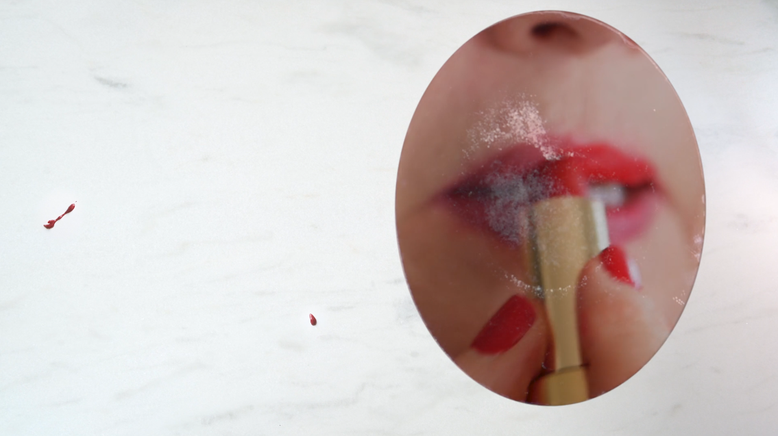 Experimental video still 'SHE' at Icebox Project Space, close-up of a person applying red lipstick in a mirror, with some smudges on the mirror surface.