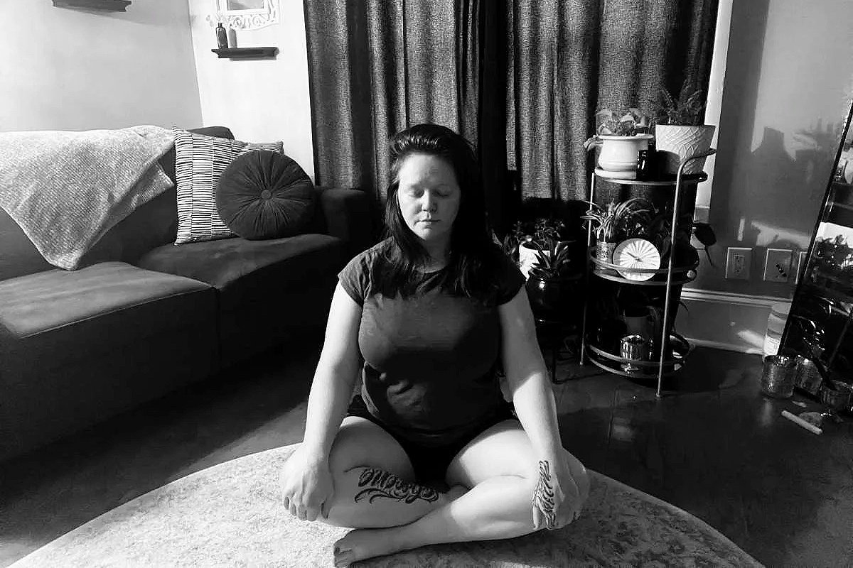 River Drosera sitting cross-legged in a meditative resting pose following a TRE® Tension and Trauma Release Exercises session
