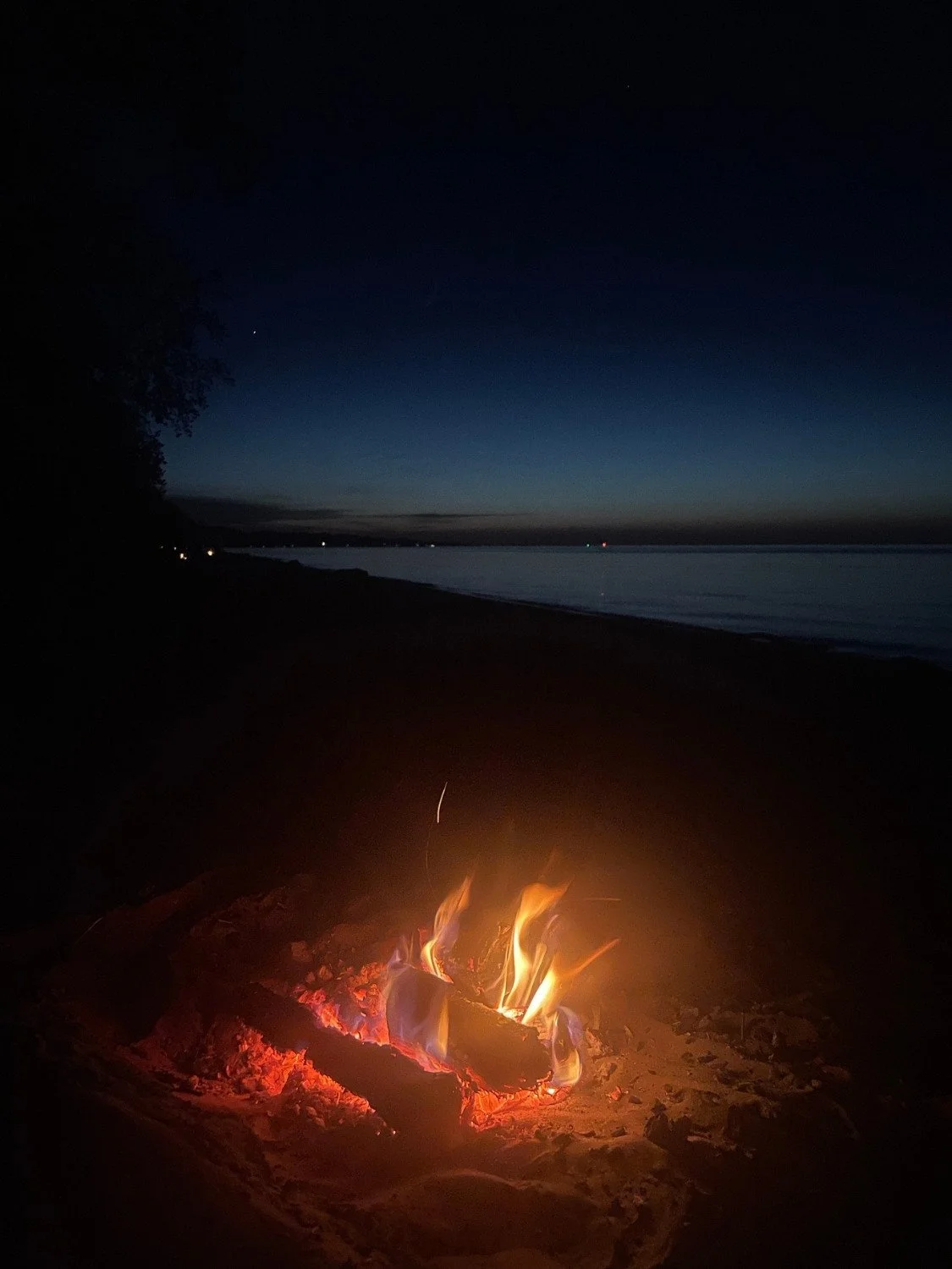 Bonfire on the beach at Lake Ontario Rochester NY at sunset evoking the depth and embodied awakening of somatic sex education