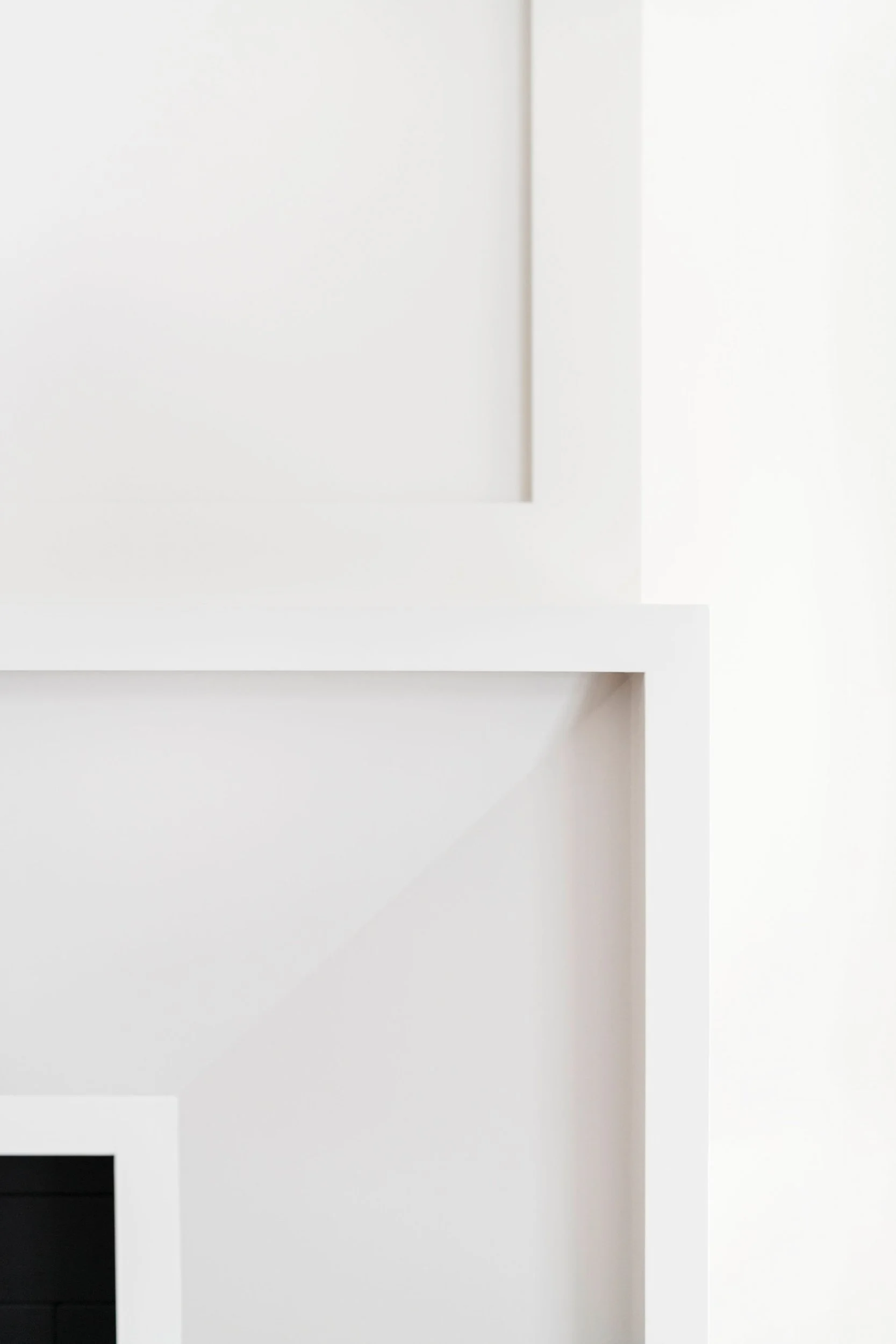 Minimalist white geometric wall design with sharp lines and shadows.