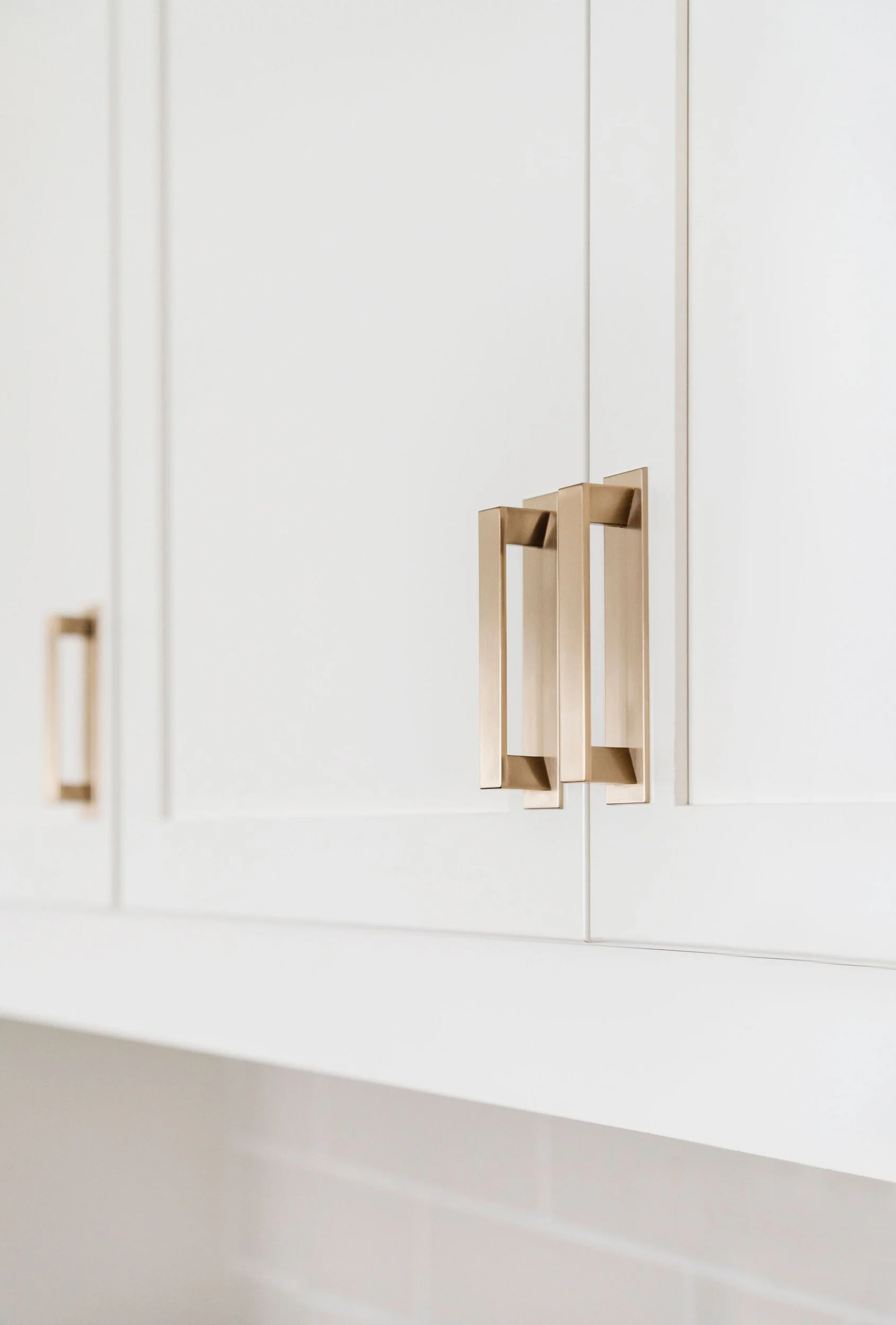 White kitchen cabinets with gold handles