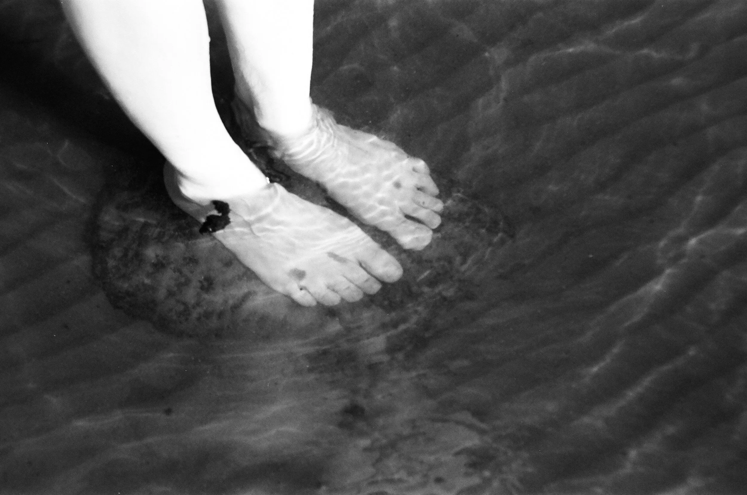 Feet in clear water with ripples