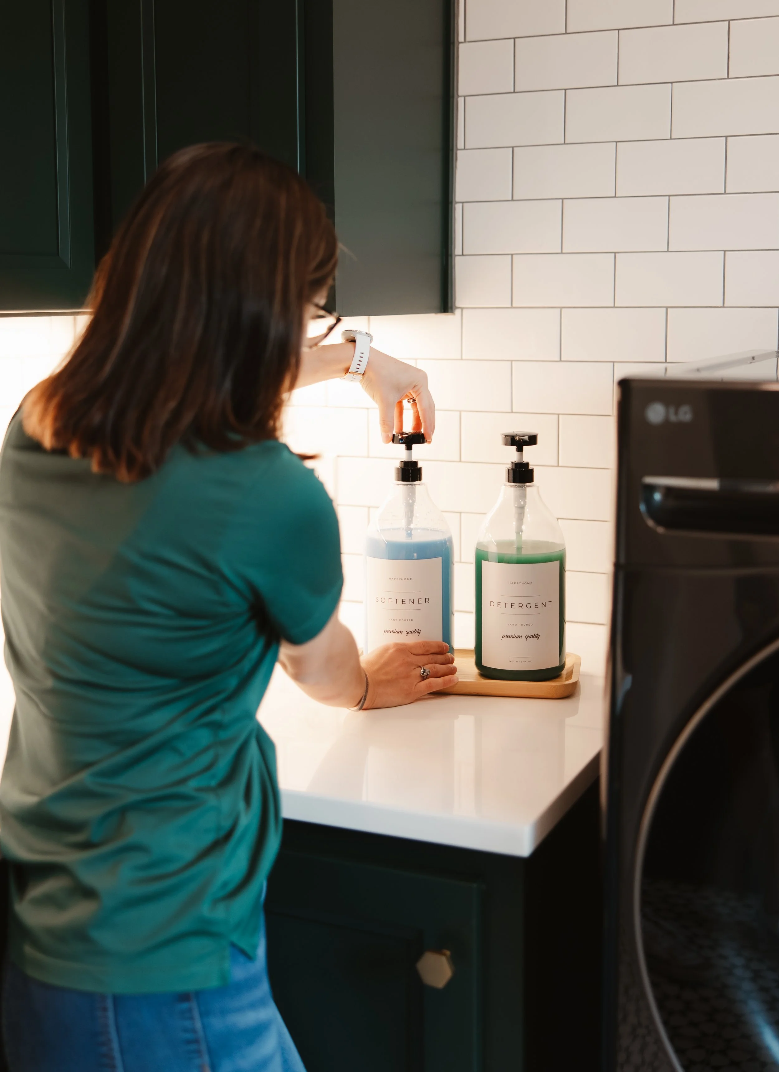 professional organizer adjusting laundry softener pump that's been labeled.