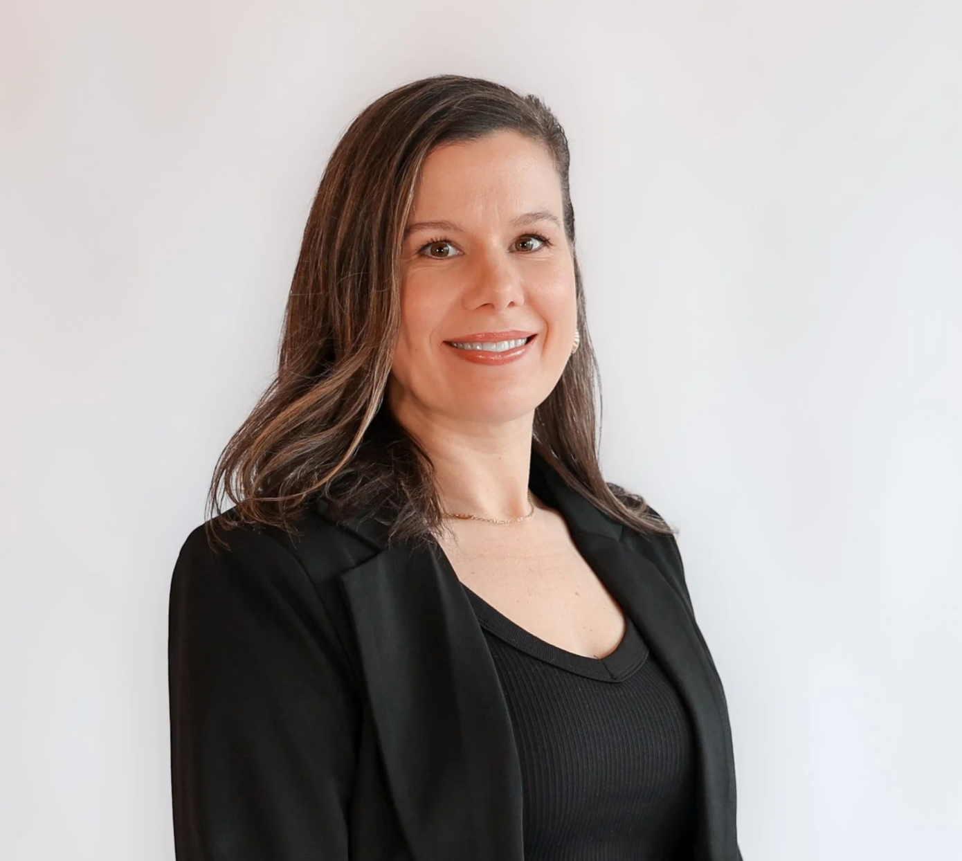 woman wearing black and has brown hair smiling