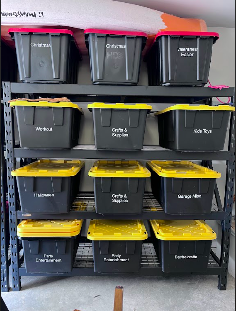 a garage shelving unit that has black and yellow totes with even labels displayed on them with contents in the bins