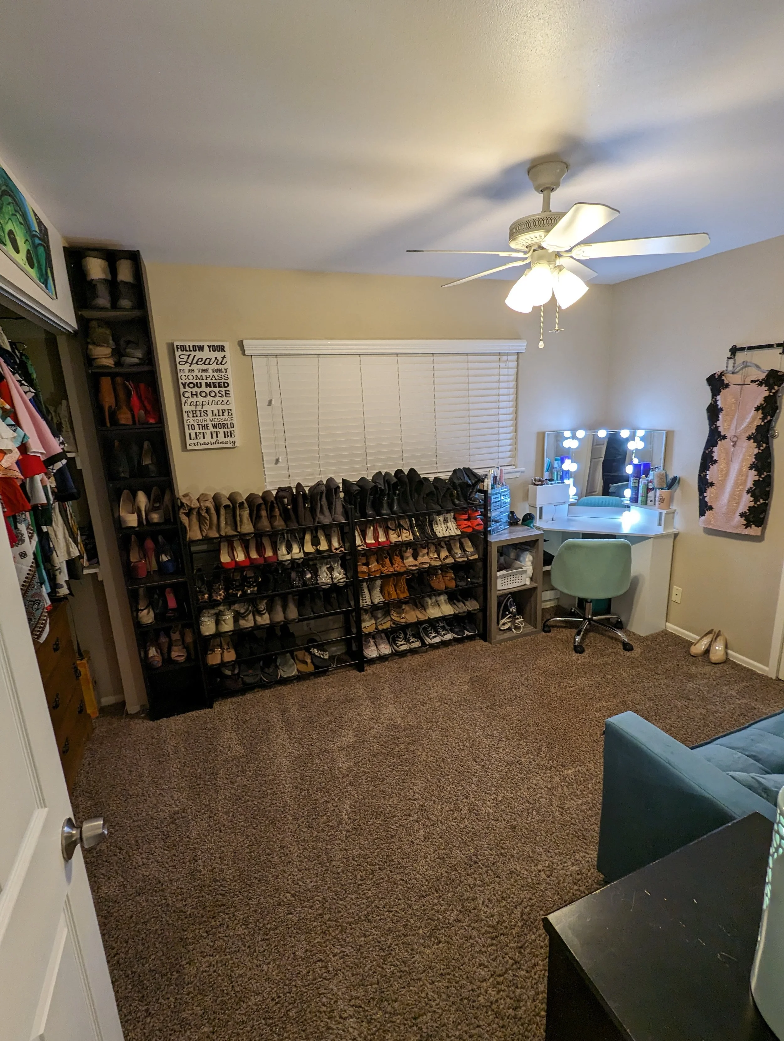 a wardrobe room with a vanity and a large shoe rack