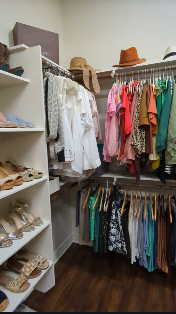 closet with color-coded clothes and organized shoes and hats