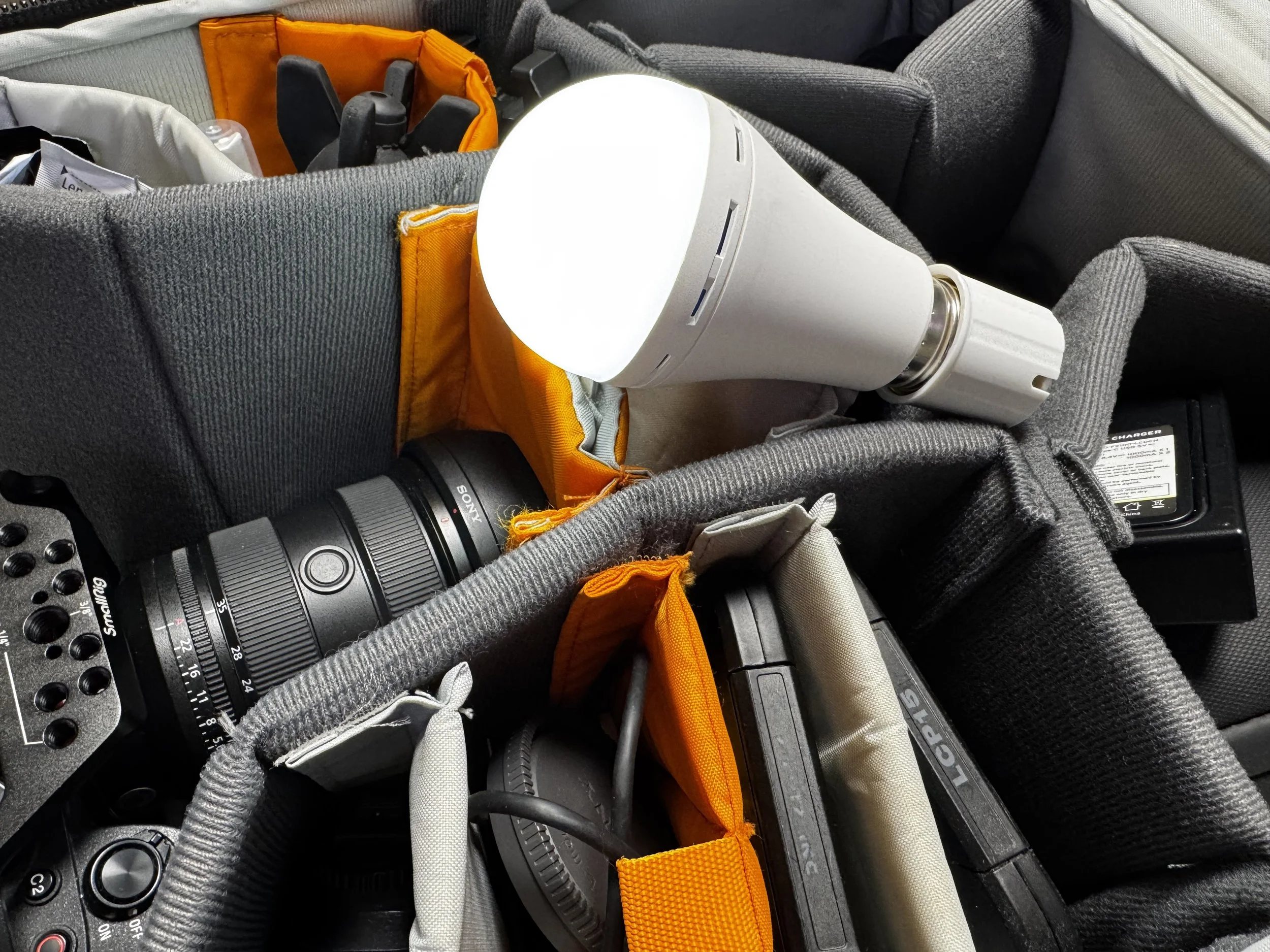 Battery-powered LED light bulb in a real estate photographer's camera bag, Gulfside Media.