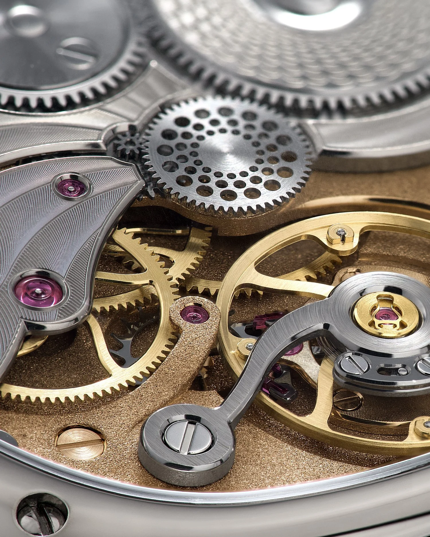 &bull; Caliber 233
Besides its unique asymmetrical design, our Calibre 233 features two other distinctive characteristics:
1. The hour wheel (with all the holes) is located on the back side, unlike a conventional movement. This is due to our hidden i