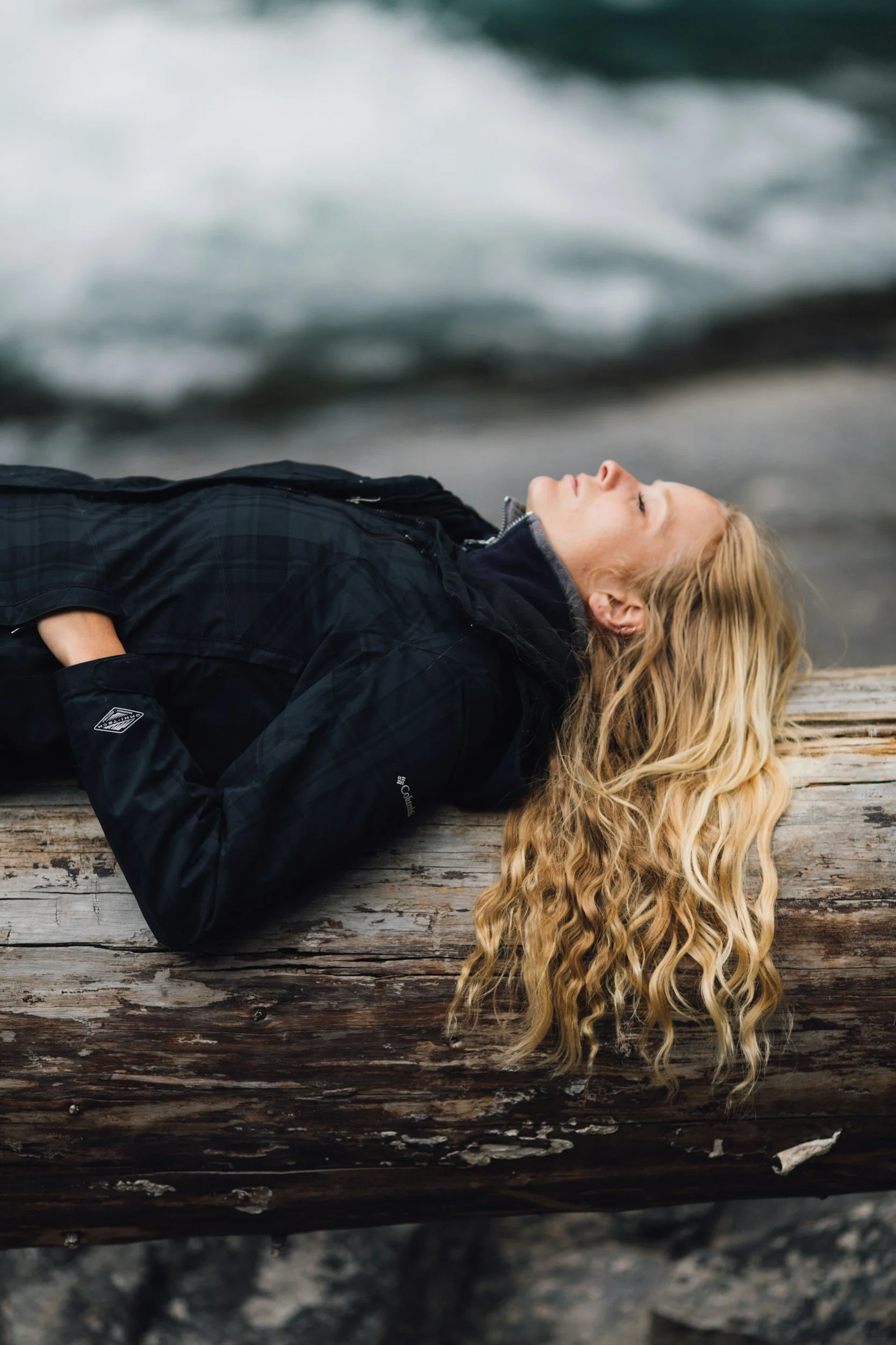 Woman pausing in nature on a log