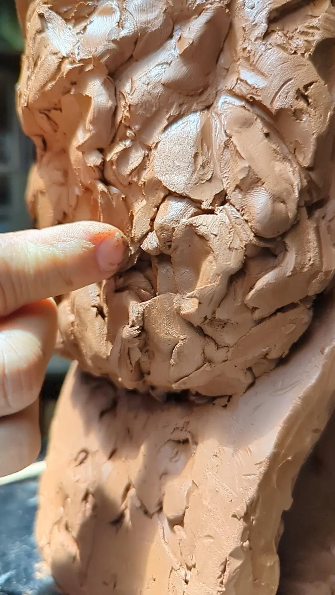 artist modeling texture on clay bust.jpg
