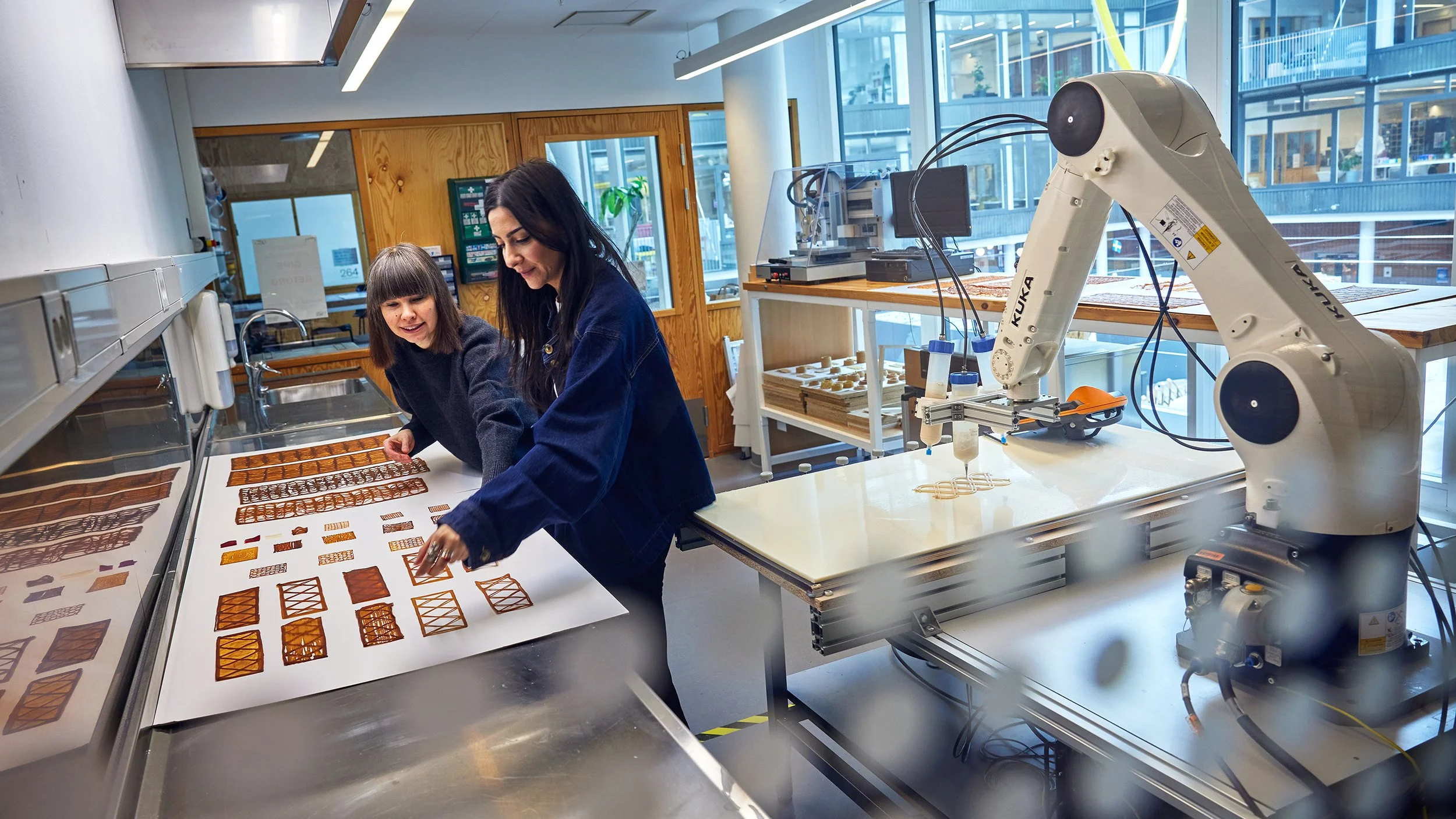 Las investigadoras de la Universidad Tecnológica Chalmers Malgorzata Zboinska y Yagmur Bektas (en primer plano) examinan prototipos de paneles arquitectónicos fabricados con un innovador biomaterial a base de levadura