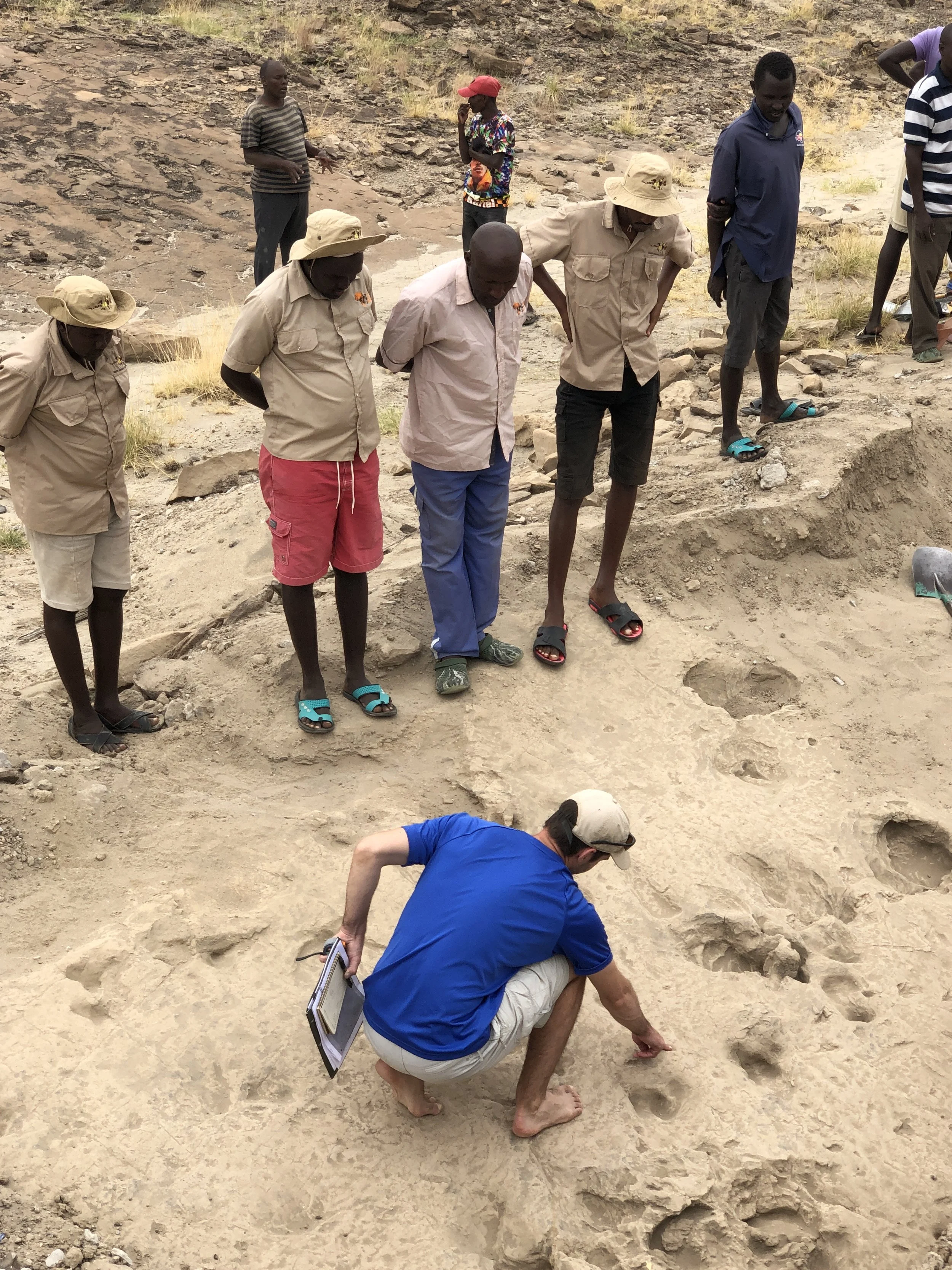 El paleoantropólogo Kevin Hatala examina junto a sus colegas la superficie del yacimiento GaJi10, en el norte de Kenia, donde se excavaron las huellas fosilizadas de Paranthropus boisei.