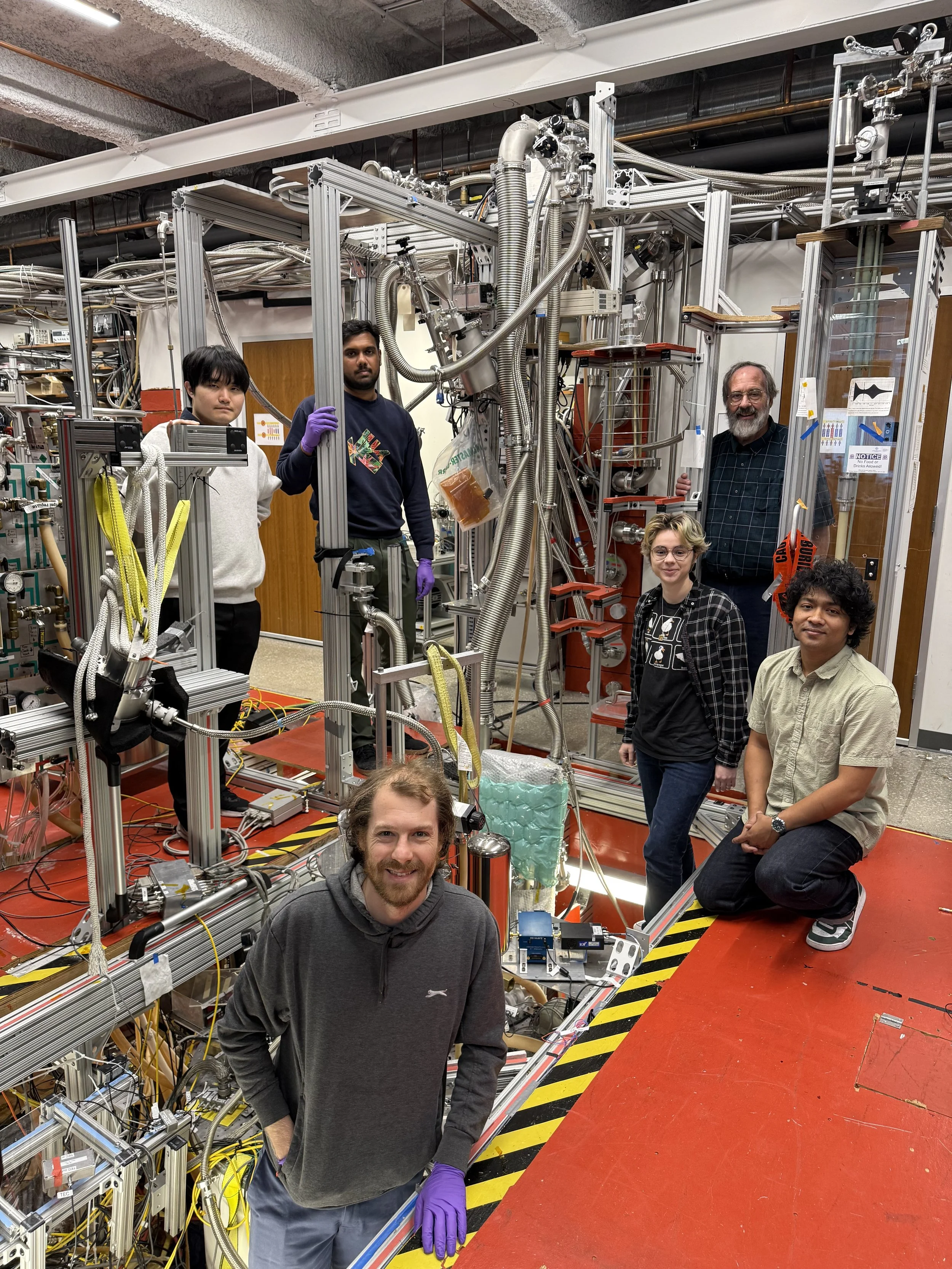 El equipo del Centro de Física Fundamental de la Universidad Northwestern, junto a la trampa de antimateria utilizada en el experimento. Al fondo, a la derecha, el profesor Gerald Gabrielse