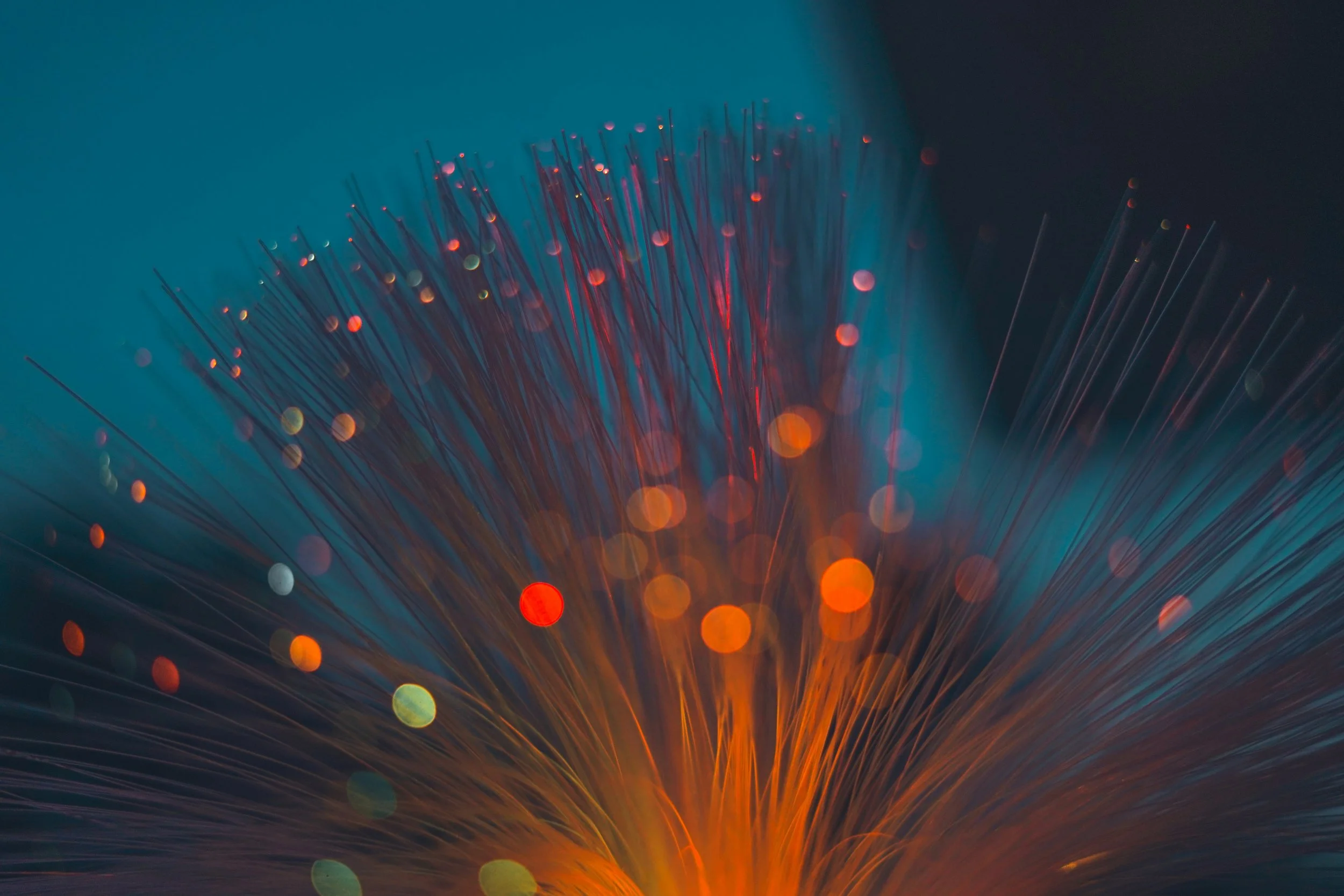 Primer plano de un haz de fibra óptica por el que viajan pulsos de luz. En las futuras redes cuánticas, estas mismas fibras podrían transportar simultáneamente datos convencionales y fotones entrelazados.