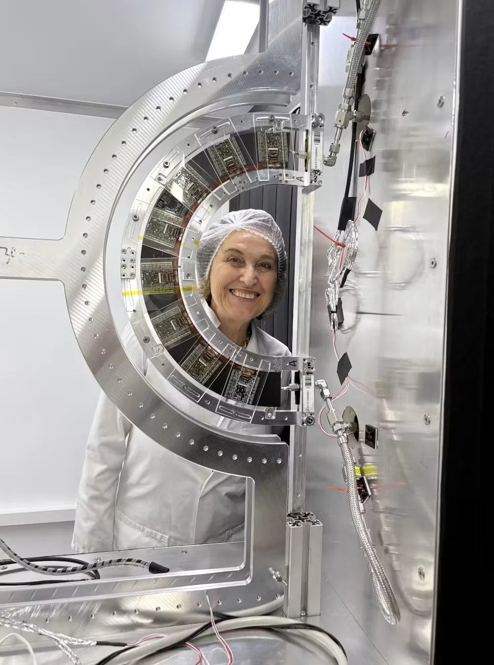 La física Daniela Bortoletto posa junto a uno de los primeros anillos construidos para el nuevo rastreador de píxeles de ATLAS, destinado al gran colisionador de hadrones de alta luminosidad.