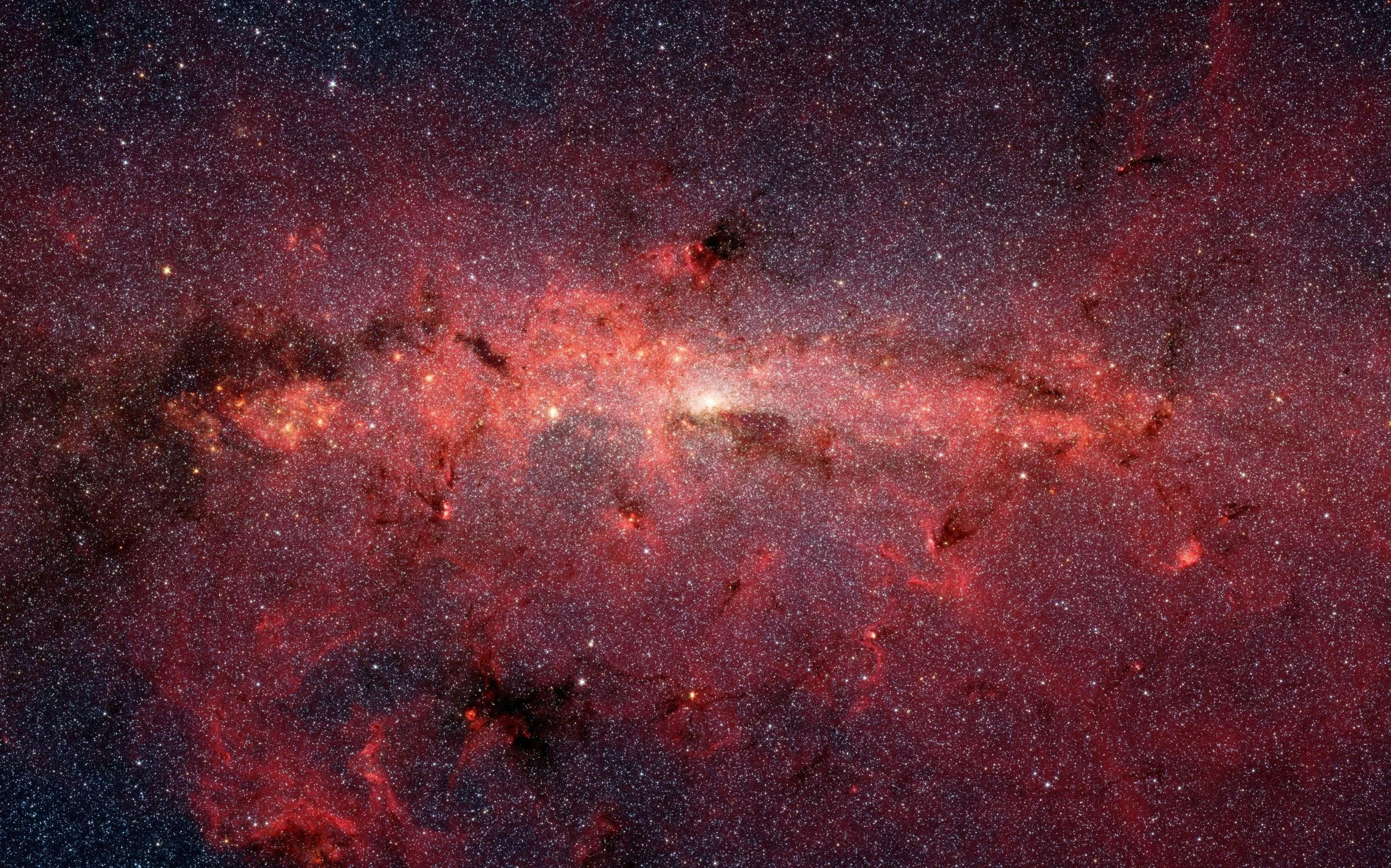 El centro de la Vía Láctea, captado por el telescopio espacial Spitzer, concentra millones de estrellas, gas y polvo interestelar.