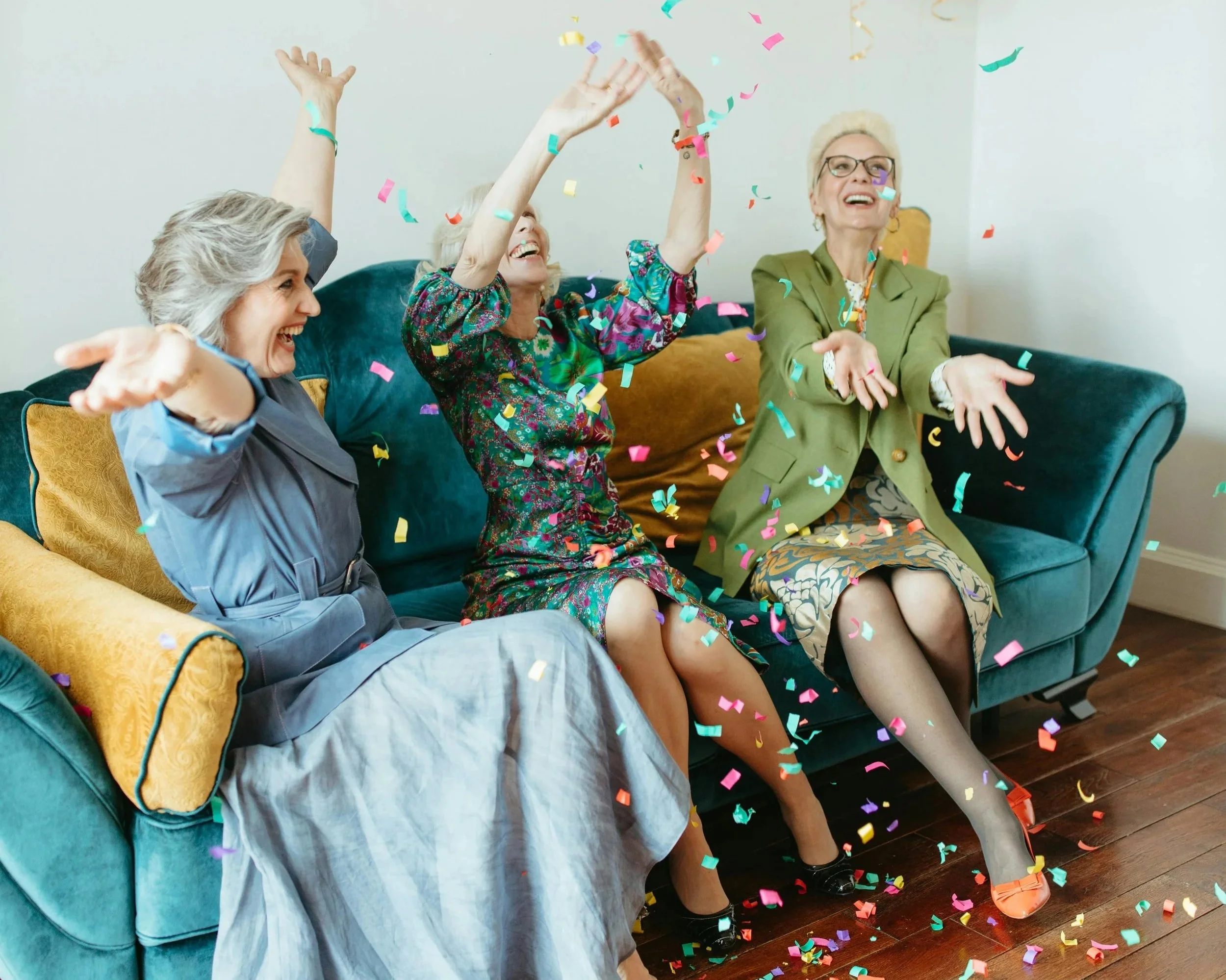 Tres mujeres mayores celebran y lanzan confeti en una fiesta, una escena que simboliza la idea que cuestiona un estudio de la Universidad  Yale
