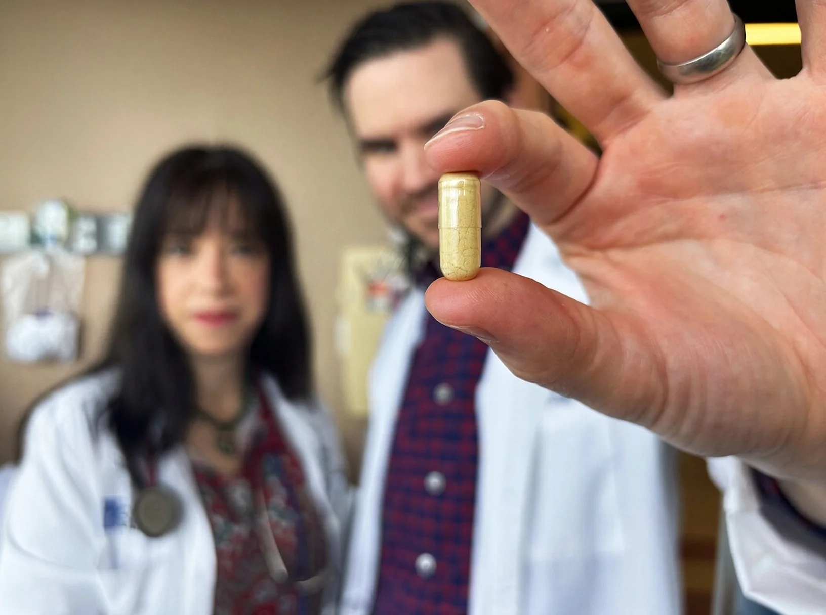 Amy Case y William Alexander, del Roswell Park Comprehensive Cancer Center, muestran una cápsula de psilocibina.