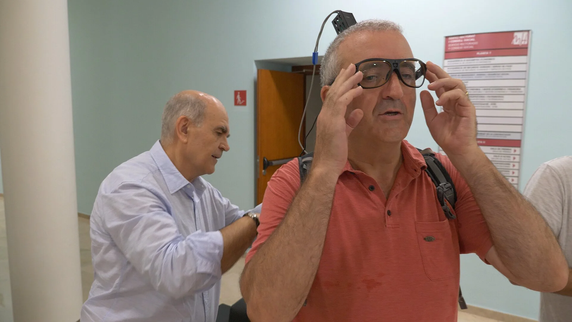 Un participante del ensayo clínico prueba un sistema experimental de visión artificial cortical, mientras el investigador Eduardo Fernández Jover, de la Universidad Miguel Hernández de Elche, supervisa el procedimiento.