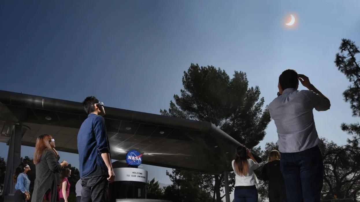 Empleados y visitantes del Laboratorio de Propulsión a Chorro (JPL) de la NASA observan las fases parciales del eclipse solar del 21 de agosto de 2017 utilizando gafas especiales.