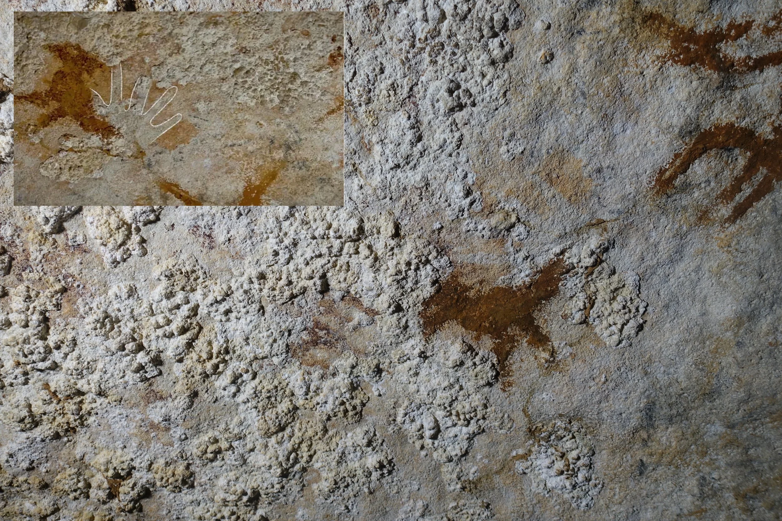 Fotografía en la que puede esbozarse la plantilla de mano de al menos 67.800 años de antigüedad hallada en una cueva de la isla de Muna, en Sulawesi (Indonesia), considerada el arte rupestre más antiguo conocido hasta ahora.