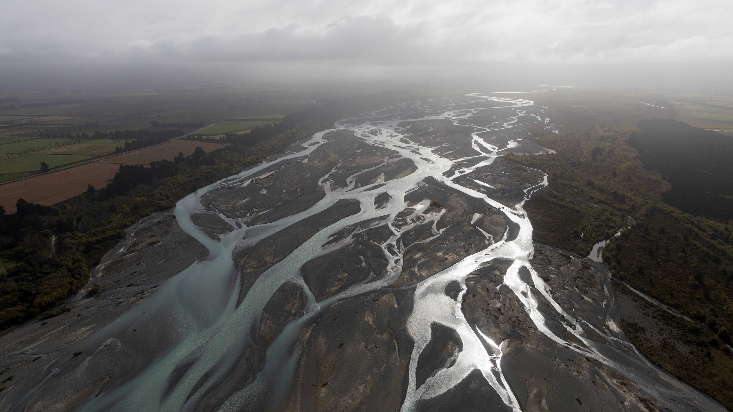 El río Waimakariri, en la Isla Sur de Nueva Zelanda, se divide en numerosos brazos separados por bancos de grava que cambian con las crecidas y el transporte de sedimentos.