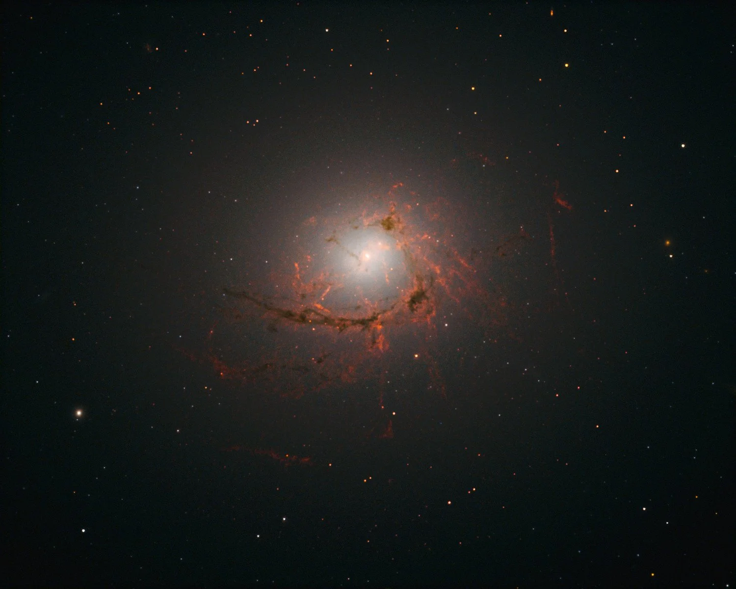 La galaxia elíptica NGC 4696, en el centro del cúmulo de Centauro, aparece rodeada por una compleja red de filamentos de gas y polvo.