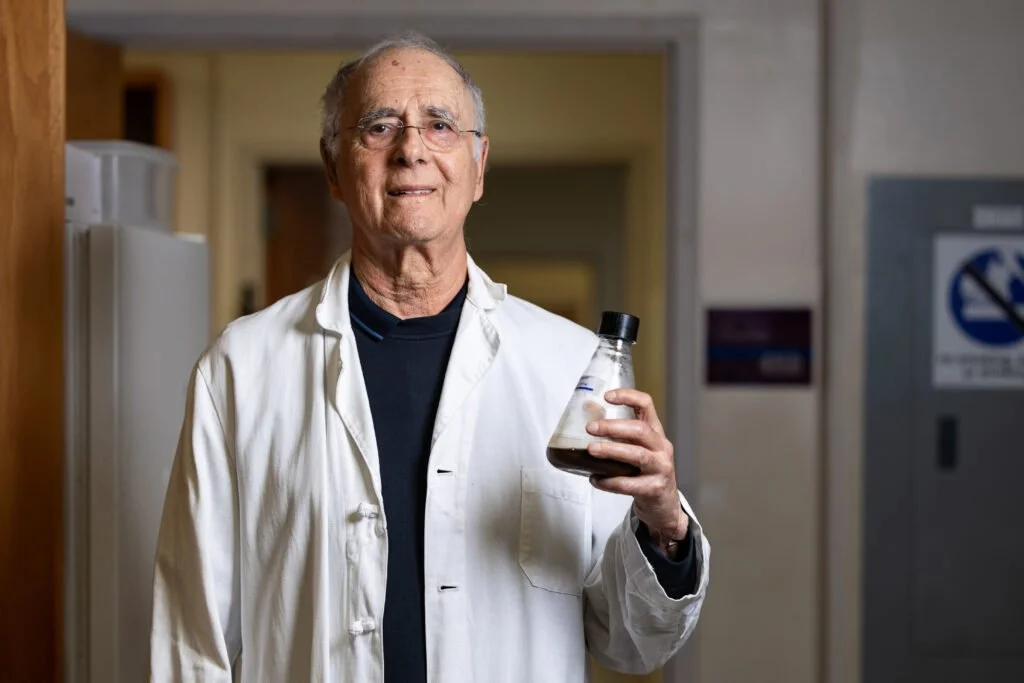 El investigador Stephen Safe sostiene una muestra de café en su laboratorio, donde estudia cómo sus compuestos activan el receptor NR4A1, una vía biológica clave relacionada con la salud y el envejecimiento.
