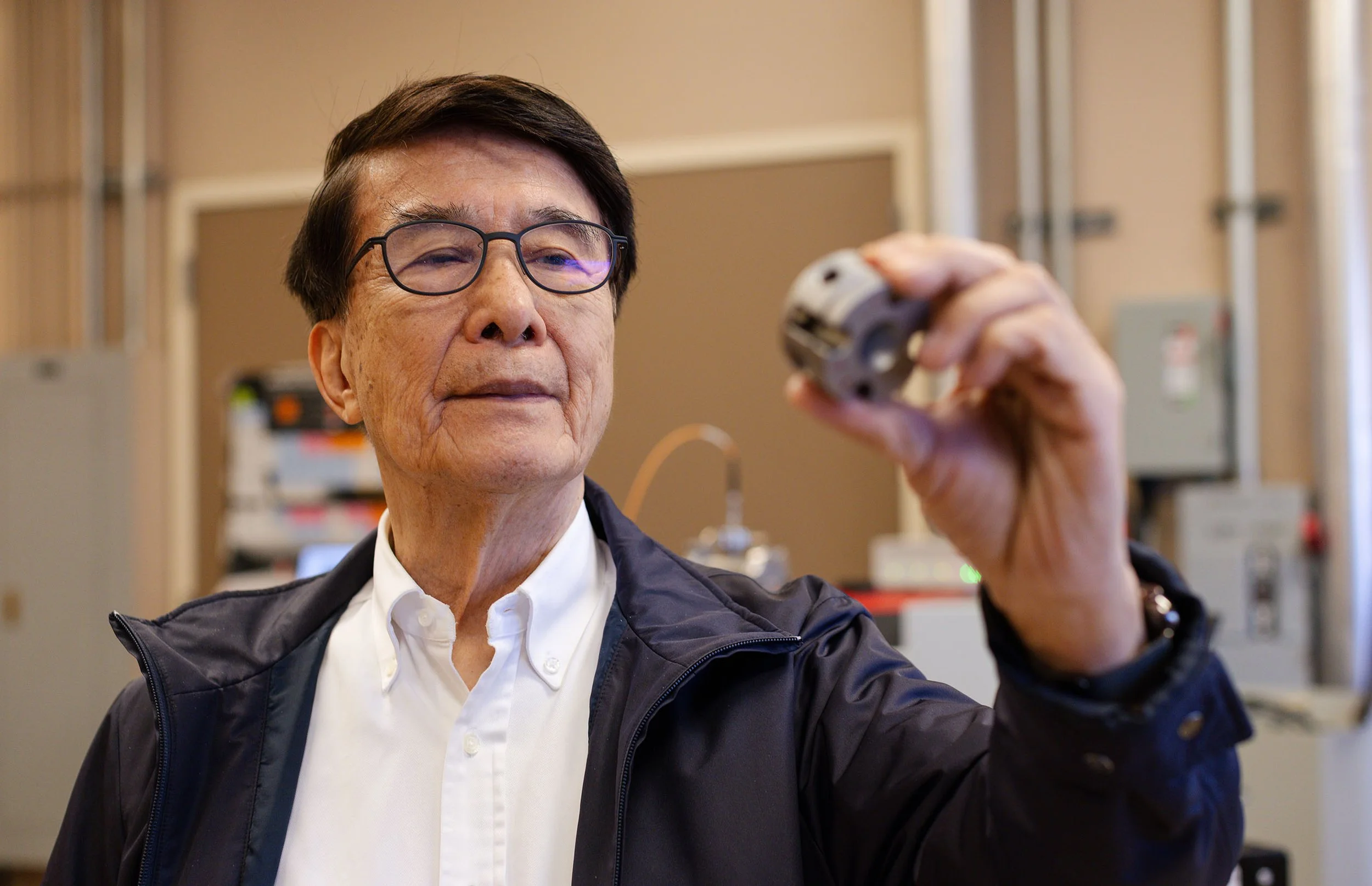 El físico Paul Ching-Wu Chu sostiene una celda de yunque de diamante (DAC) en un laboratorio de la Universidad de Houston, el dispositivo utilizado por su equipo para lograr el récord de superconductividad a presión ambiente.