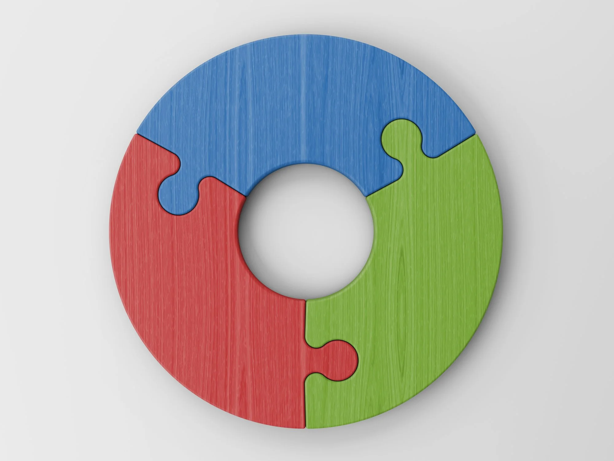 Colorful circular puzzle with four pieces in blue, red, green, and blue, assembled to form a ring with a blank center on a light gray background.