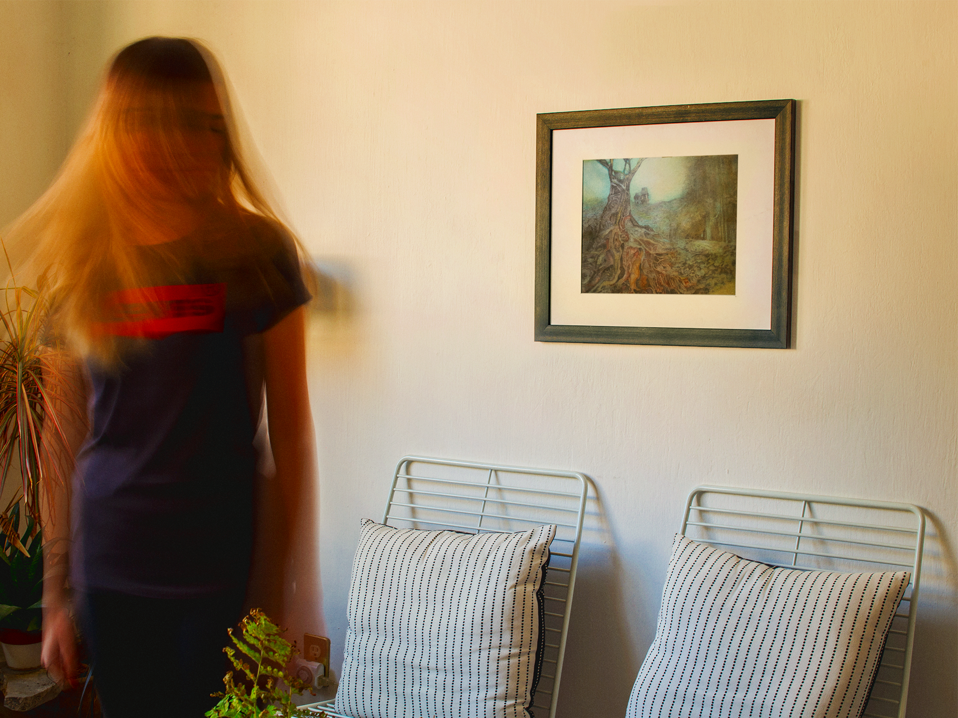 blonde-girl-moving-her-hair-while-a-framed-art-print-template-is-on-a-white-wall-a14771.png