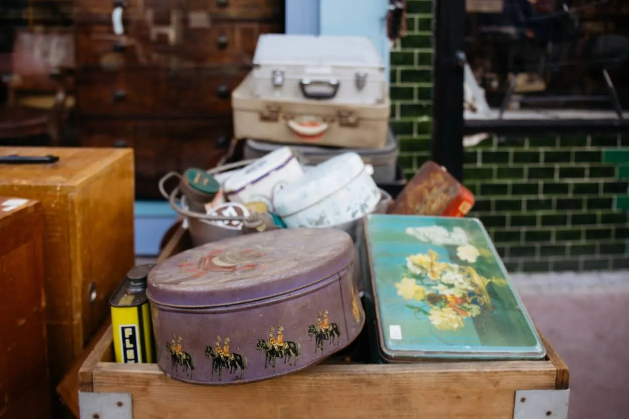 Table with old canisters and suitcases.