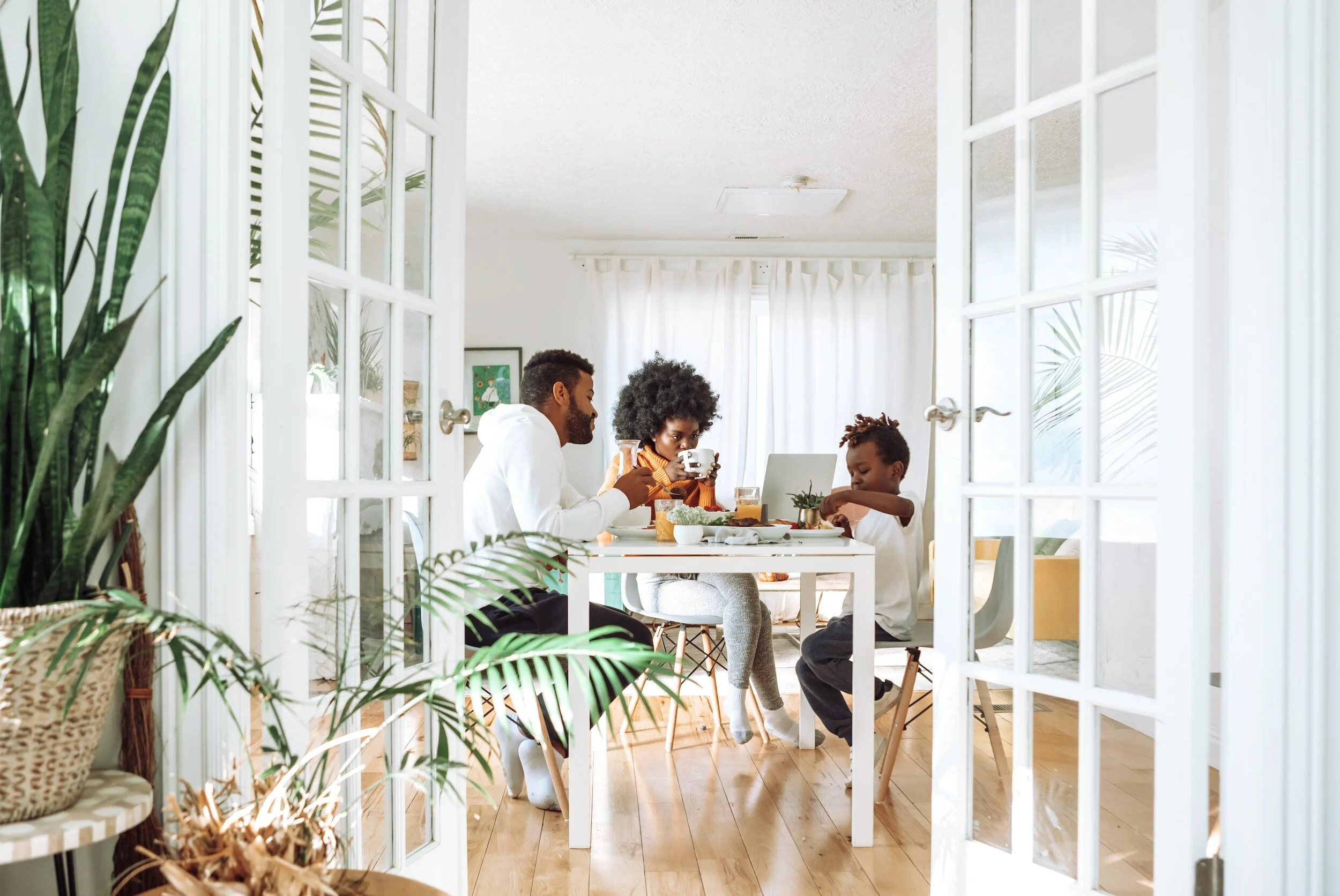 Two adults and one child sitting at a dining room table.