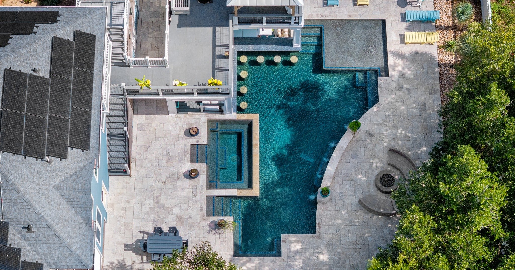 It's hard to beat colors like these!

Designed with a blend of radial edges and straight lines, this backyard retreat features a built-in spa, swim-up bar, wet deck, and a waterfall feature, making it the perfect place to relax, entertain, and enjoy 