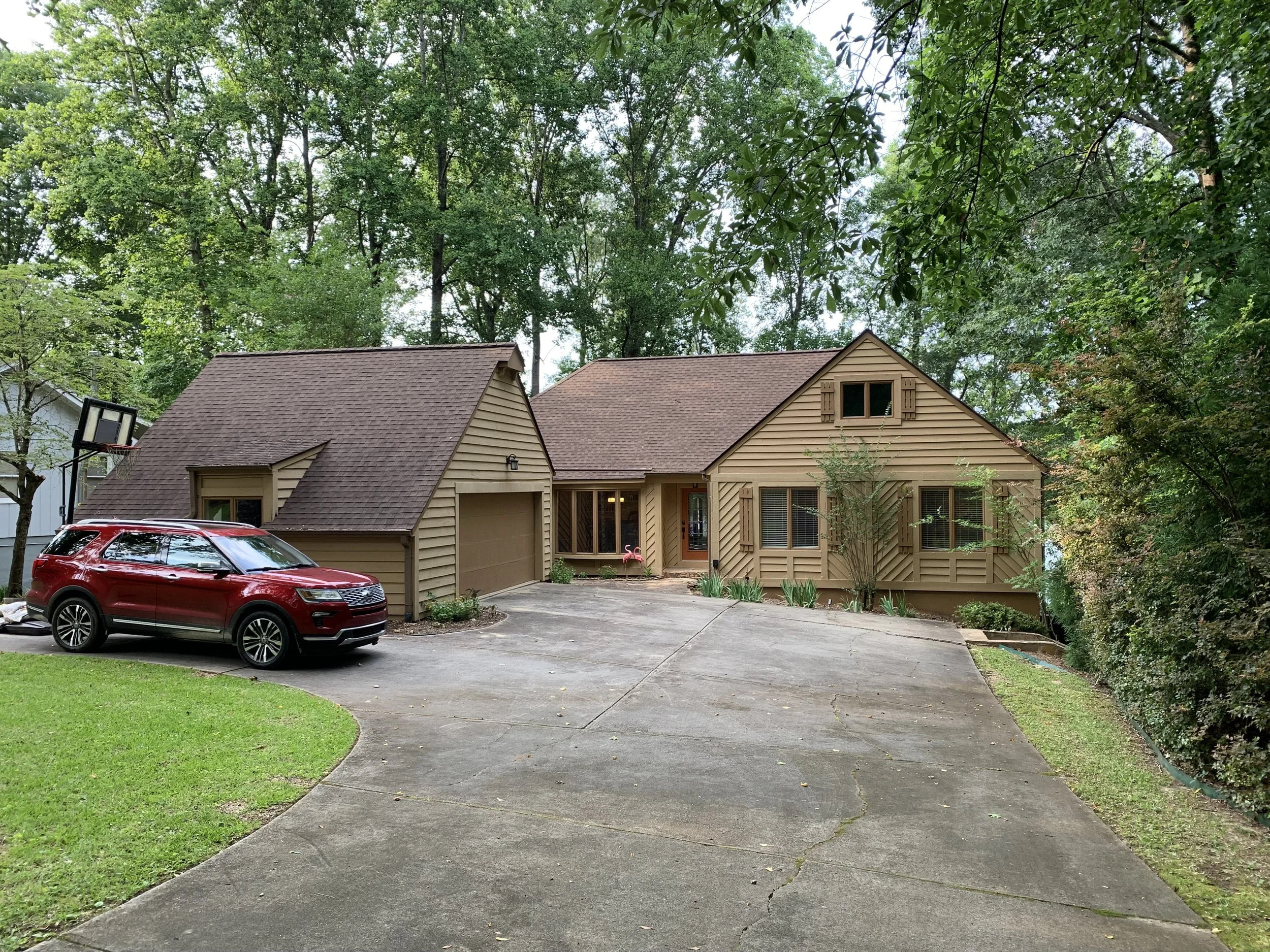 Driveway with parking area for up to four cars at front of home.  Walkway with four steps to right of house leads to back yard and lake.