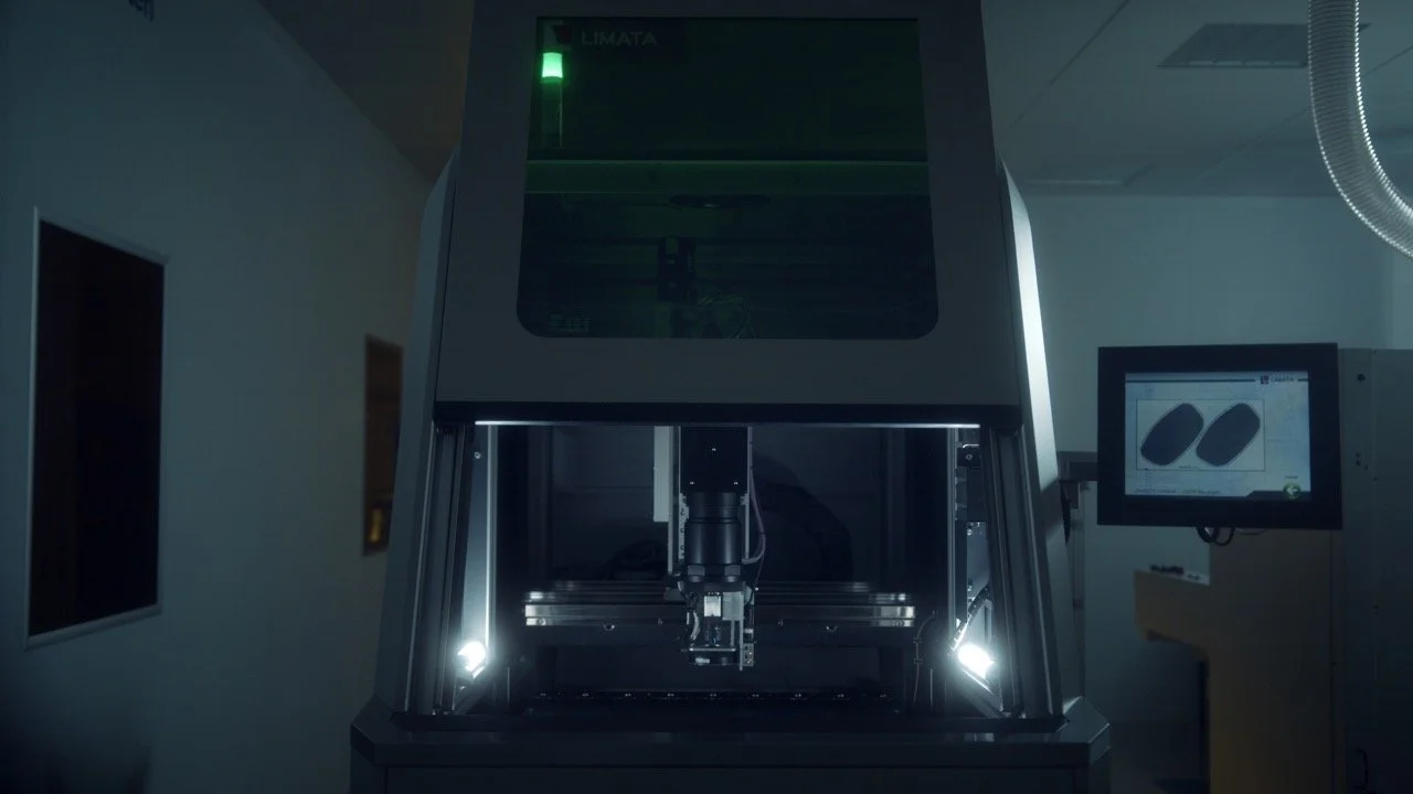 A large industrial machine with a computer screen showing two oval shapes, likely used for manufacturing or testing components in a factory or laboratory setting.