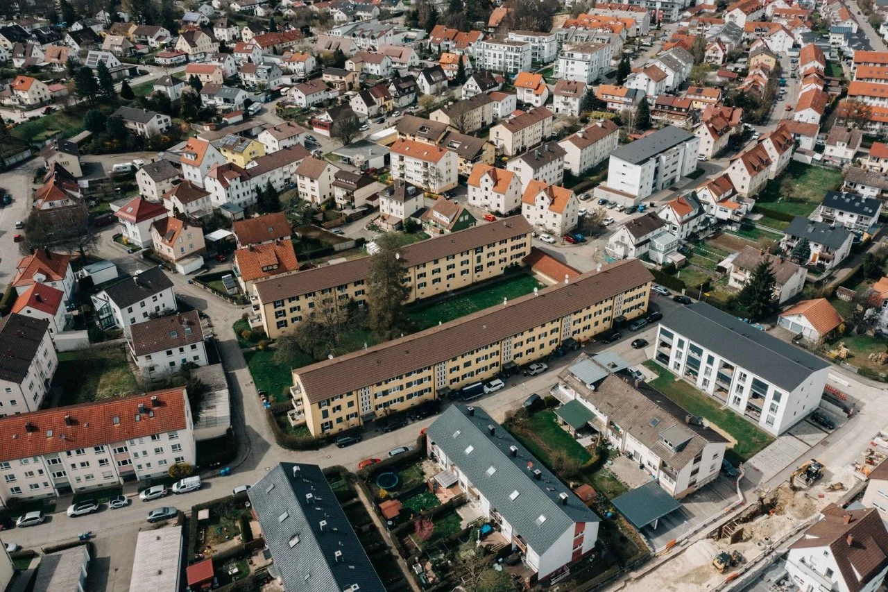 Aerial view of a residential neighborhood with a mix of single-family homes and apartment buildings, with some construction work visible in the lower right corner.