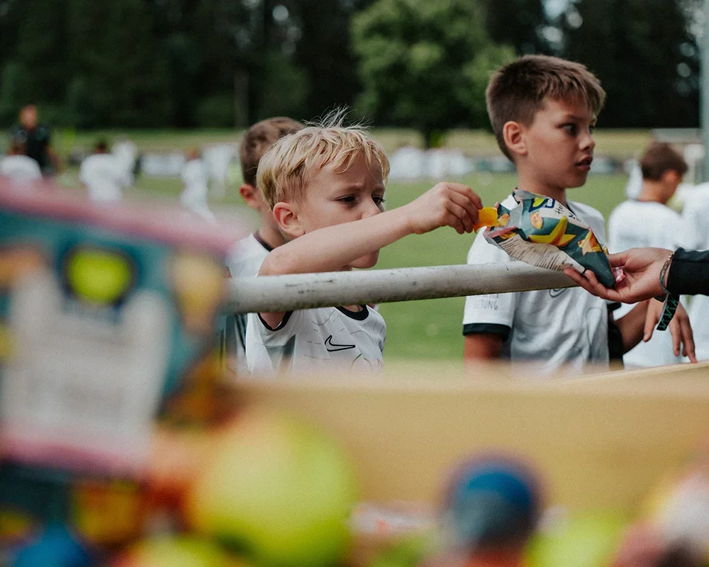 Children at an outdoor event waiting in line for snacks.