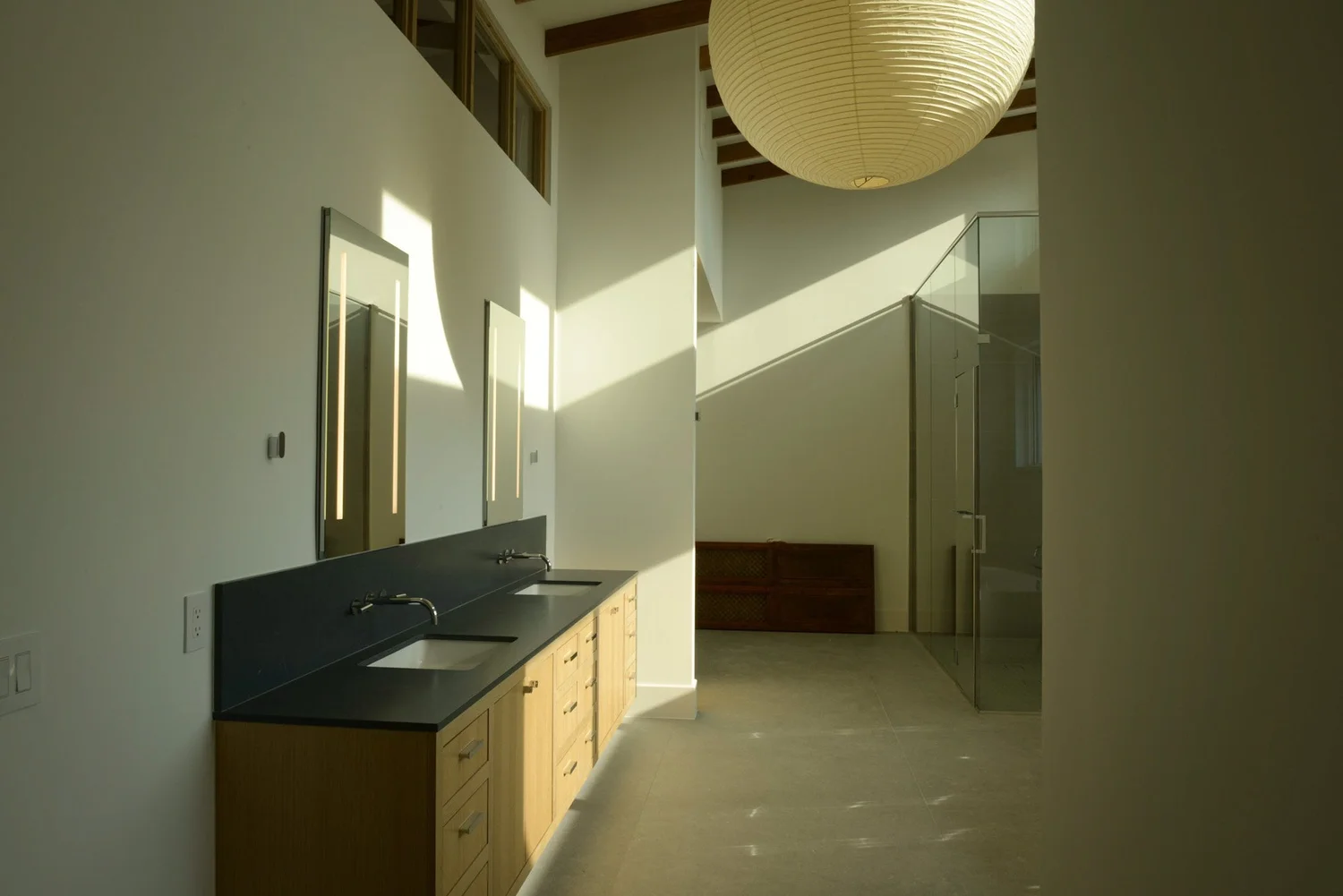 Cedar Creek primary bathroom with a double vanity, glass shower, and pendant light