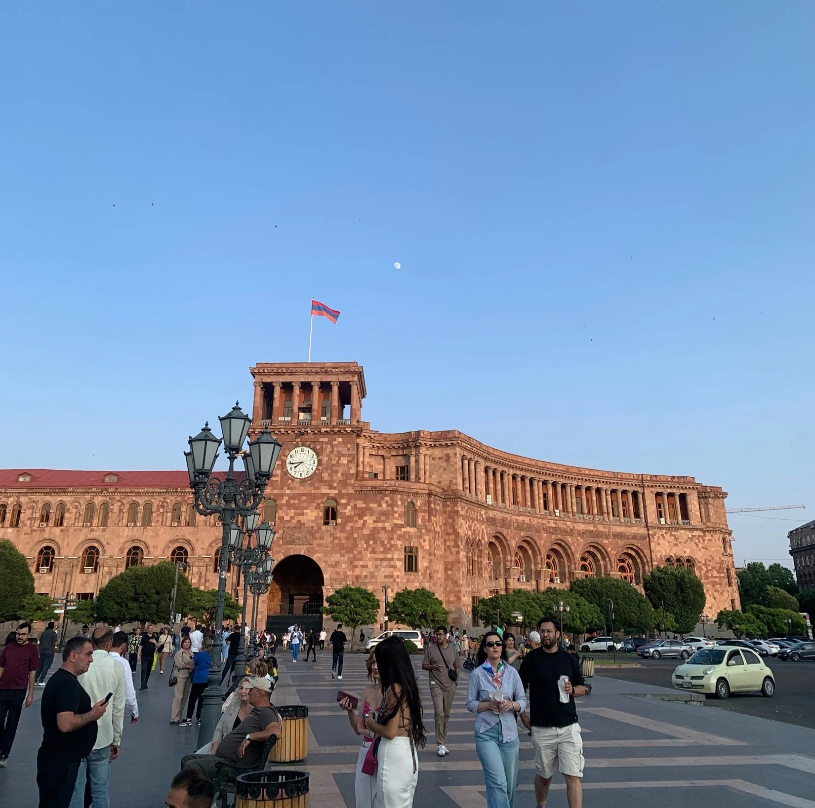 The twilight dawdles onto the scene, and the streets still bustle with life as dim lights turn on. 