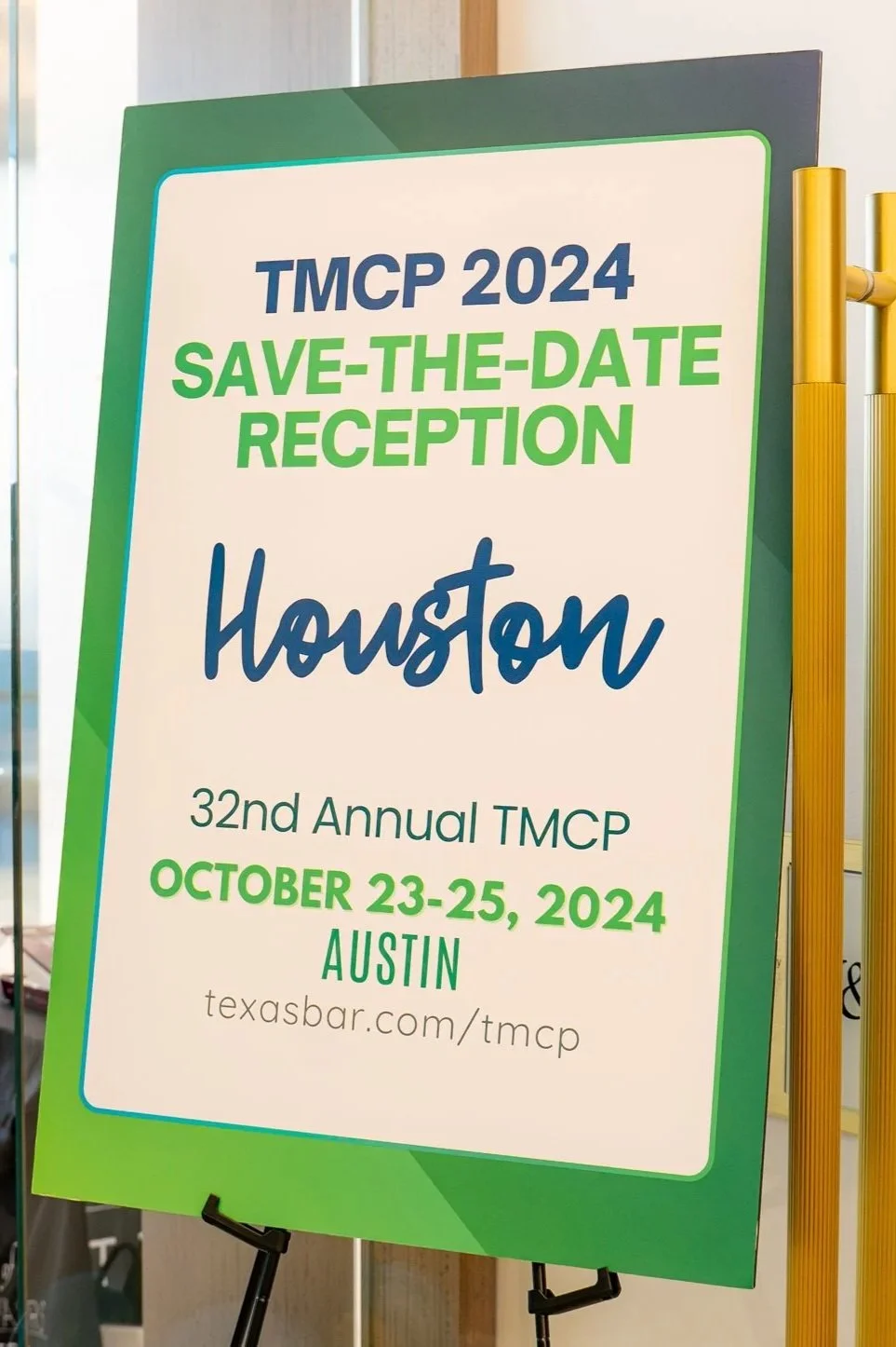 A conference sign for the 32nd Annual TMCP in Houston, scheduled for October 23-25, 2024, in Austin, with a website link texasbar.com/tmcp.