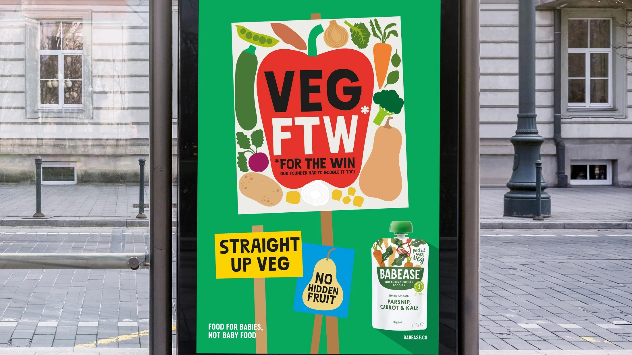 A colorful sign promoting vegetarian and vegan foods with illustrations of vegetables like a carrot, onion, broccoli, spinach, and peas. The sign features text such as 'Vegan for the Win,' 'Straight Up Veg,' and 'No Hidden Fruit.' It also advertises Babease organic baby food with a green logo and mentions it is suitable for babies, not baby food.