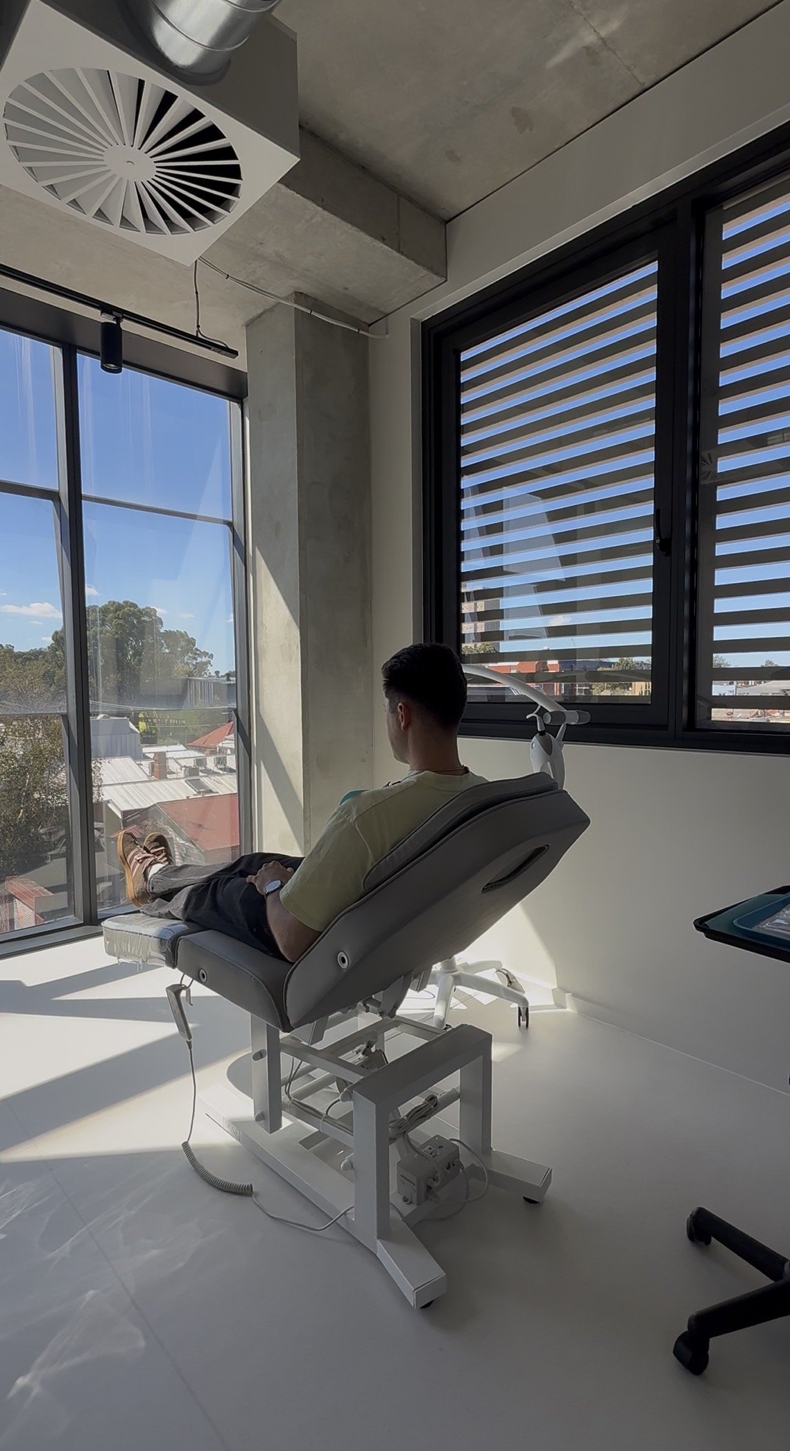 A young man with brown hair and blue eyes smiling at a dental appointment.