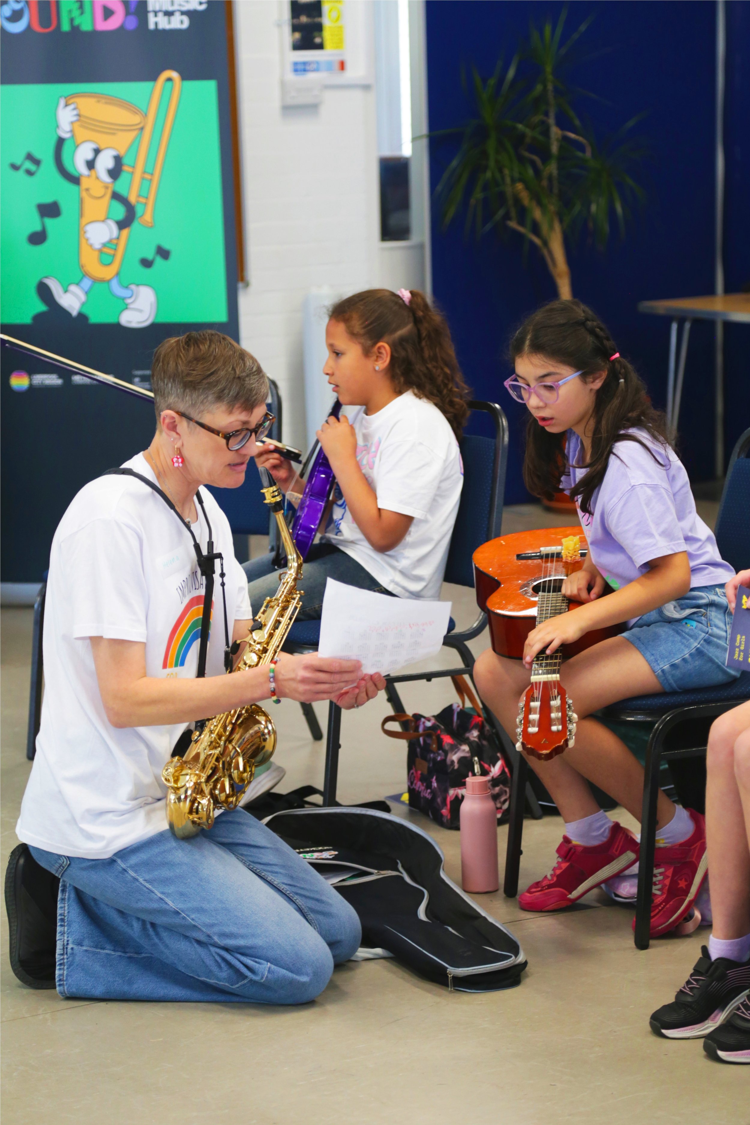kneeling music leader with camp participant