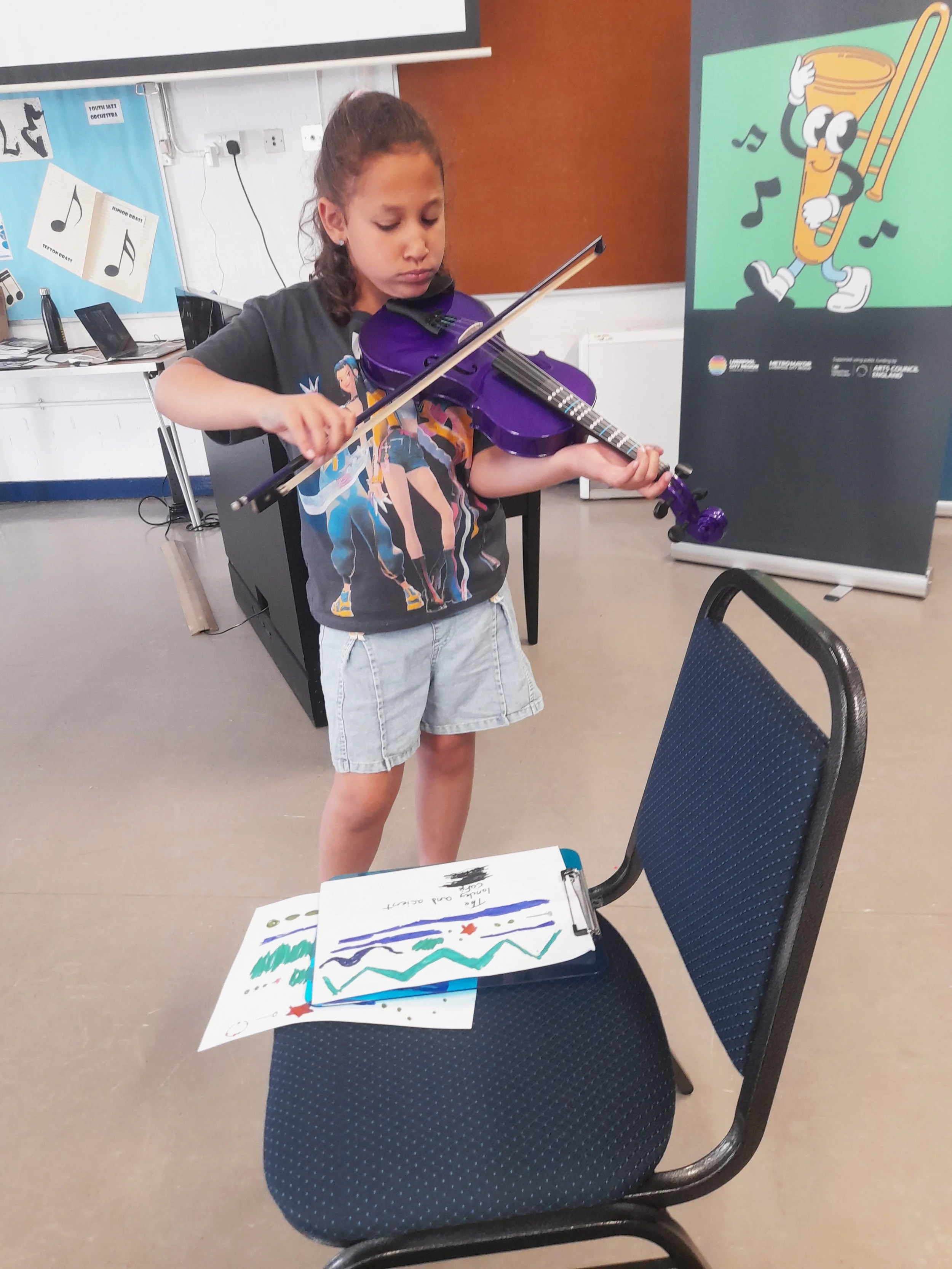 participant standing playing a purple violin