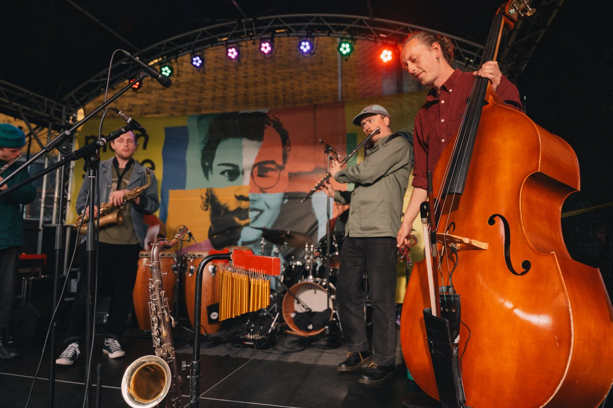 members of the band ancient infinity orchestra standing on stage at manchester jazz festival