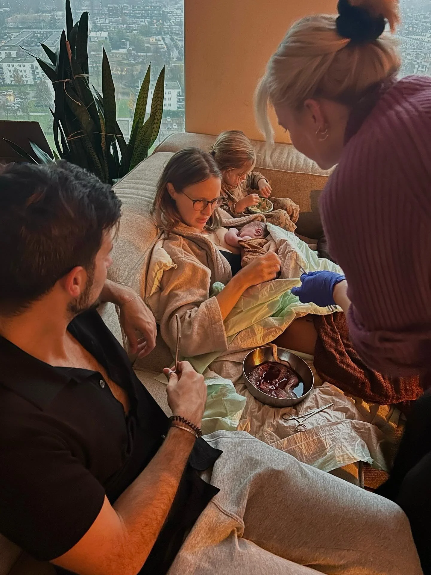 DEEL 4/ Mia wordt een beetje jaloers dus ik moedig haar aan om in het bad te komen. Daar komt ze, poedeltje naakt in het bloederige water, maar het maakt haar niks uit. Ze kust haar broertje.
De placenta volgt na zo&rsquo;n 15 minuten, met wat hulp v