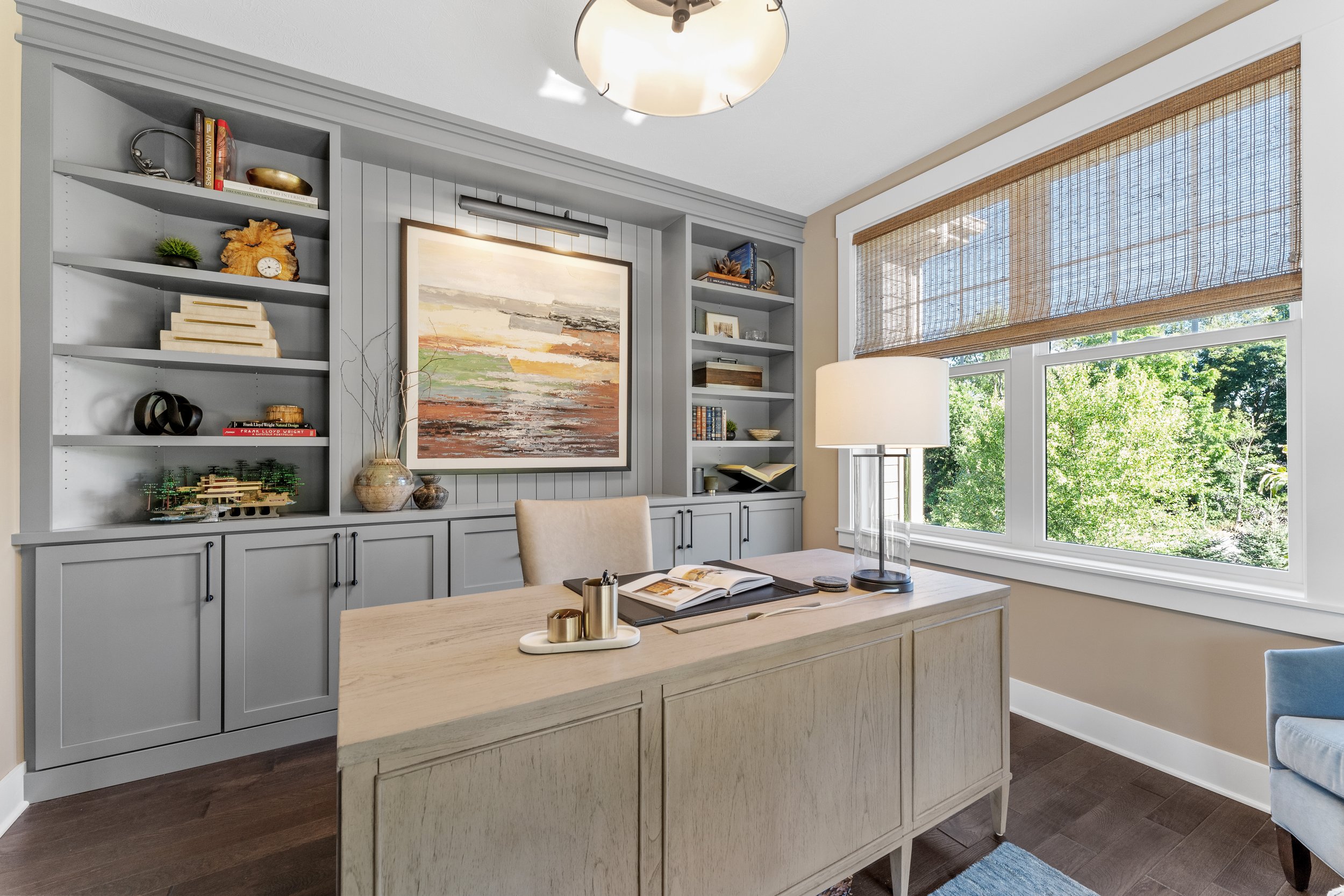 Bright modern office with light wood accents and blue‑gray walls in a clean, neutral palette.
