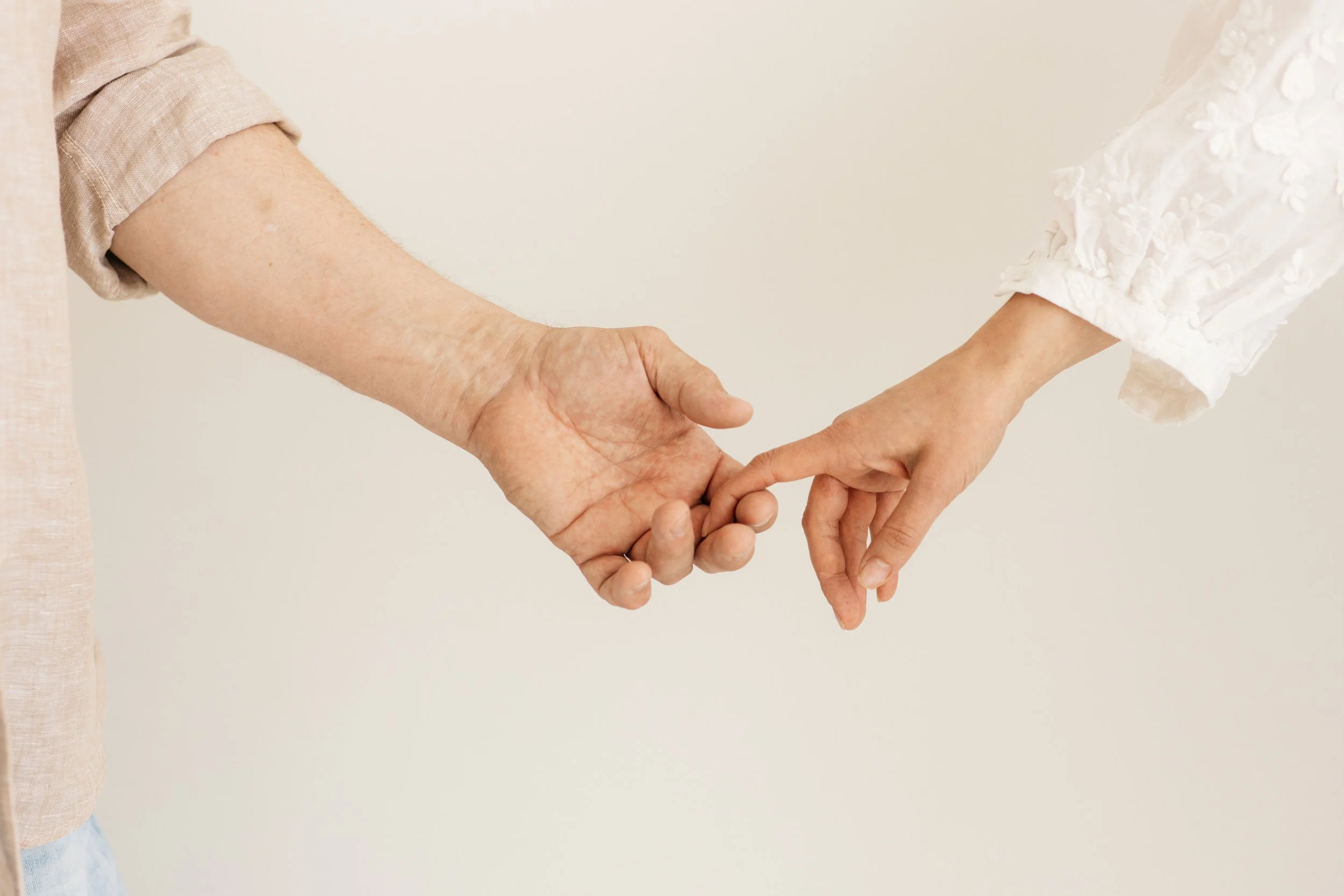 Kaksi ihmisen kättä koskettavat sormenpäitä ja pitää yhteyttä.